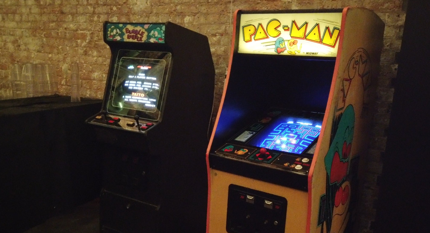 A Bubble Bobble and Pac-Man arcade cabinet next to each other