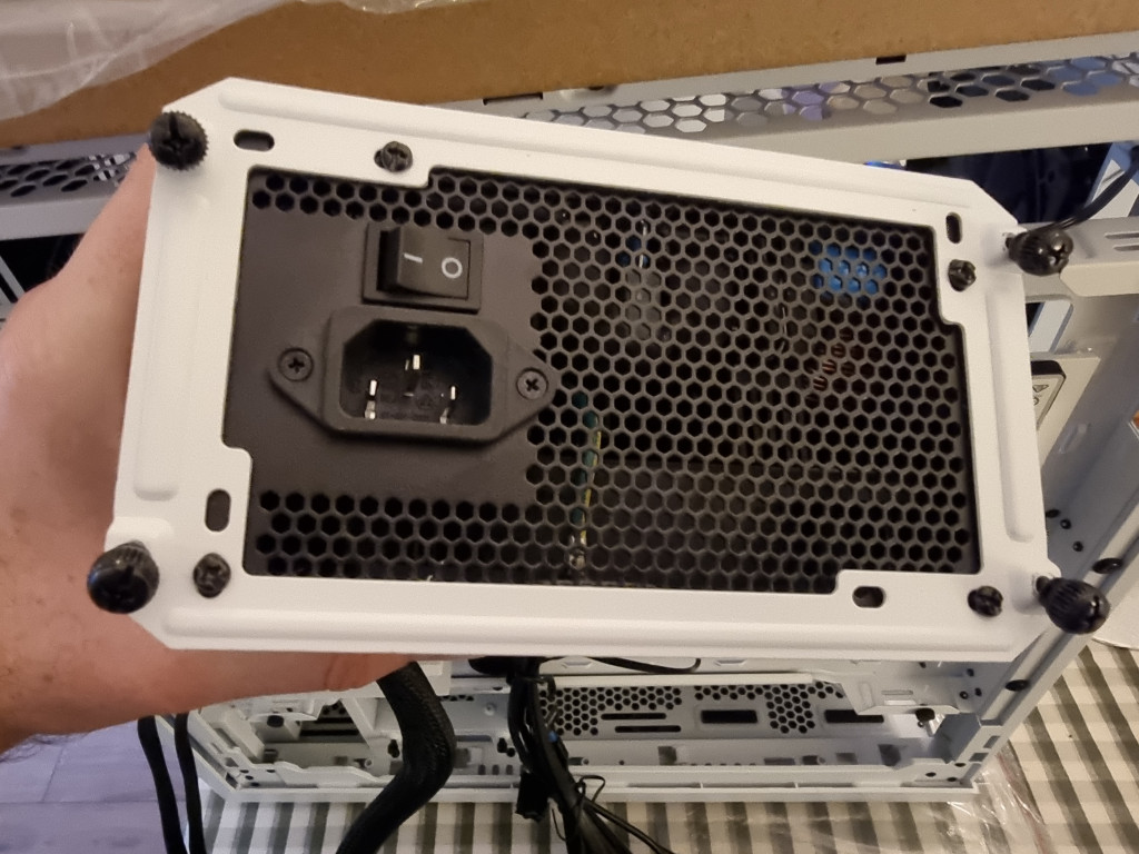 a black psu has the be quiet white frame mounted onto the rear ready to be slid into the pc case and tightened using the 4 black thumb screws.