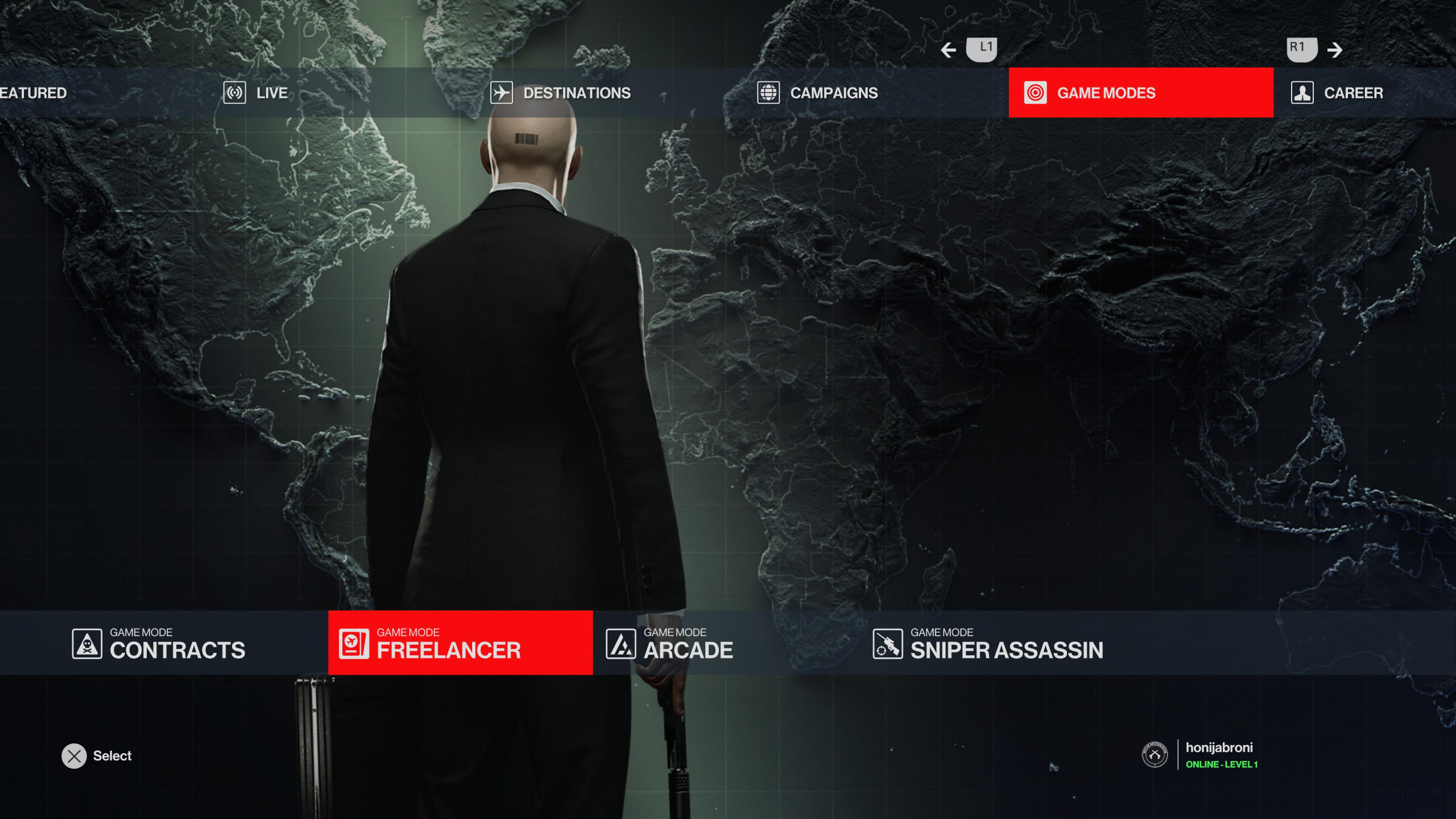 Mode select screen for Hitman World of Assassination showing the new Hitman Freelancer mode. Agenet 47 stands with his back to the camera. Hes dressed in his iconic black suit and white shirt. Hes holding his silenced pistol down by his right side.