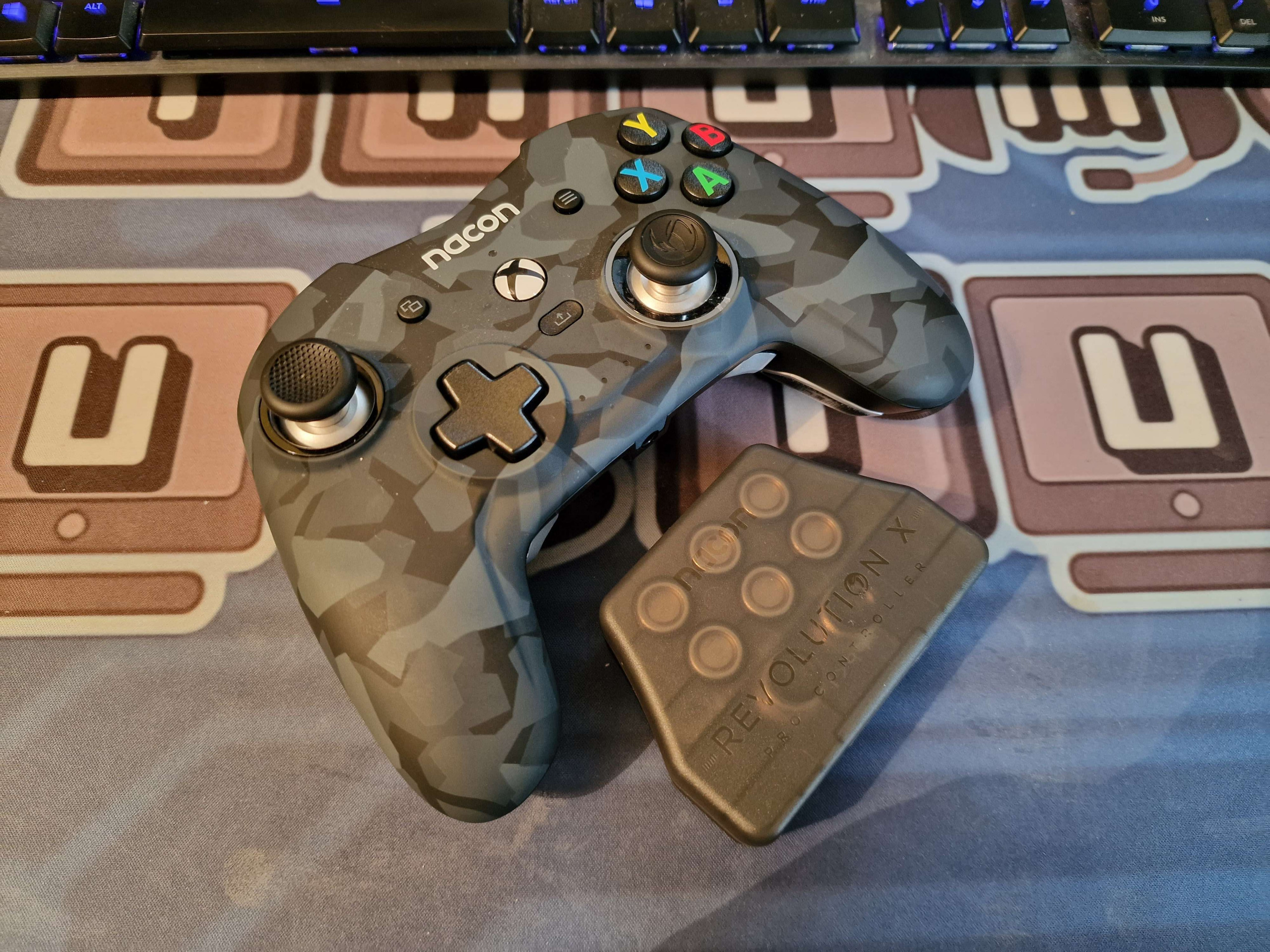 Nacon Revolution X Pro Controller sitting on top of a Thumb Culture mousemat, a small case sits beneath that contains the weights and extra thumbstick necks and ends