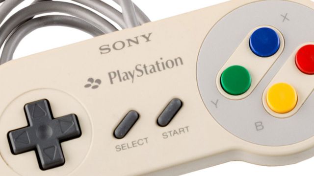 A Sony PlayStation branded controller in the shape and design of the SNES controller. It features the same button layout as the SNES with directional buttons on the left, start & select buttons in the center and the B (yellow), A (red), X (blue) and Y (green) on the right.