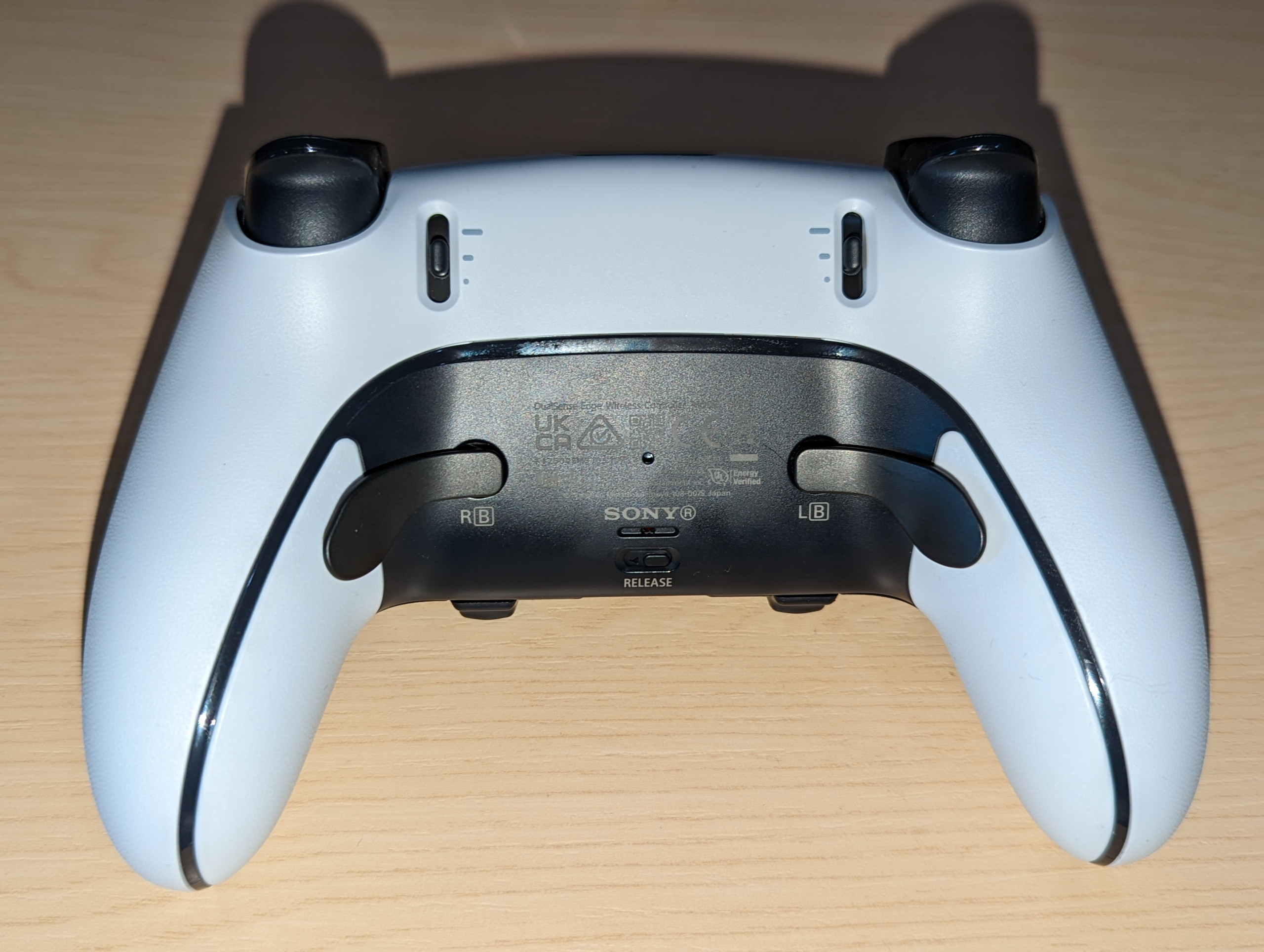 Back on the Dualsense Edge controller, showing the trigger adjustment sliders and the optional back buttons