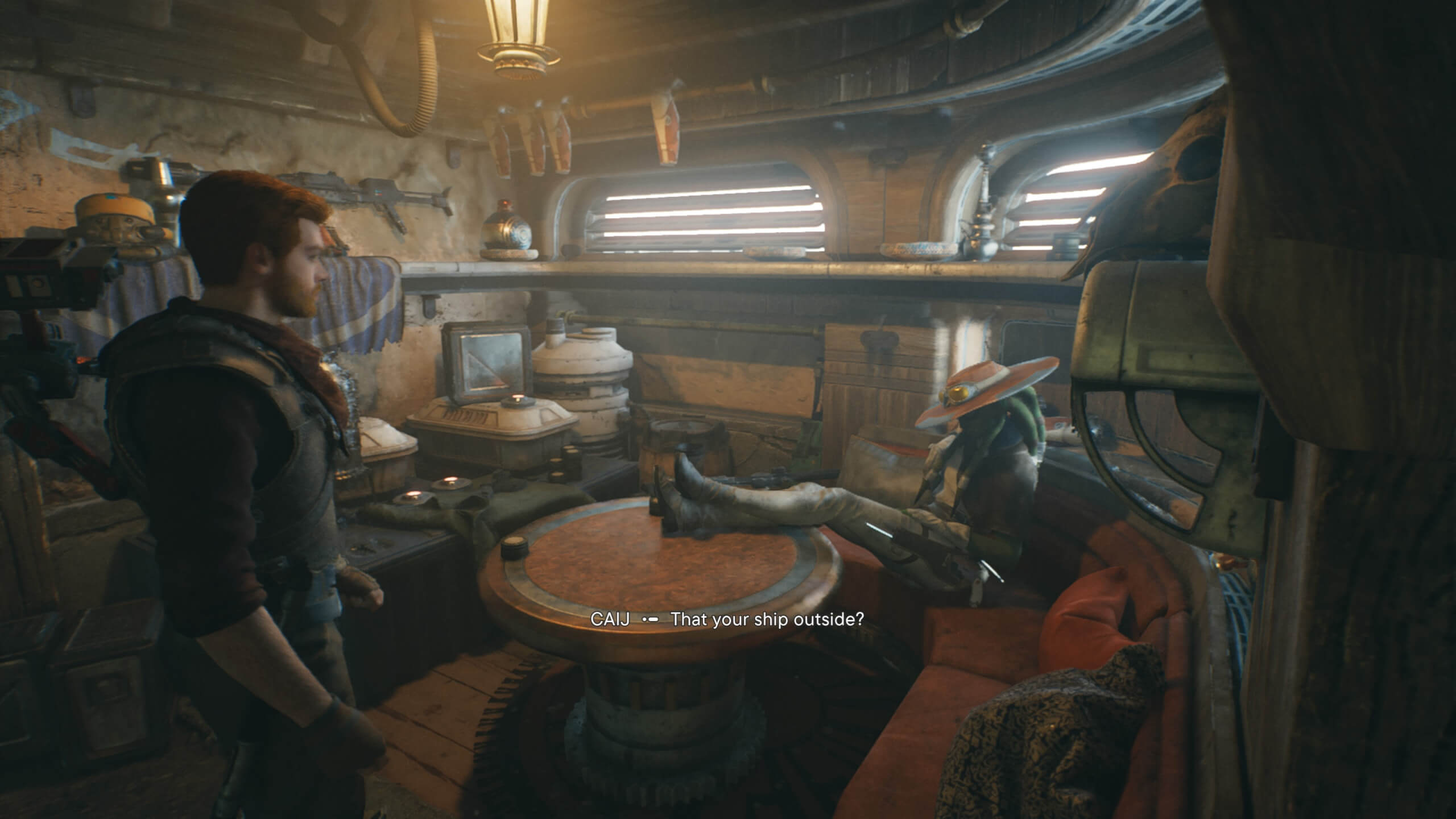 Cal is talking to a mysterious NPC in the cantina. the character is sitting at a dimly lit booth with their legs up on the table and is surrounded junk.
