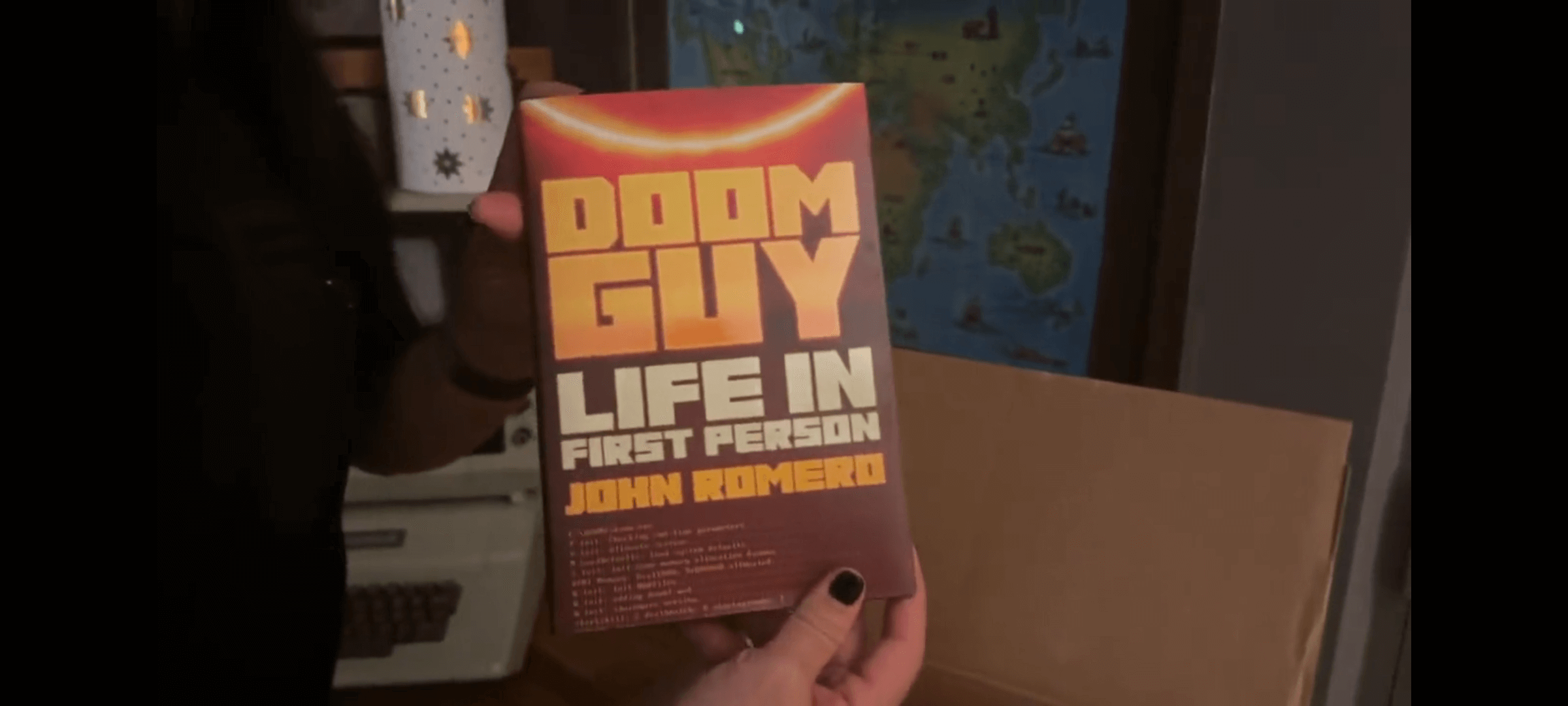 author John Romero holds his book Doom Guy Life in First Person in his hands
