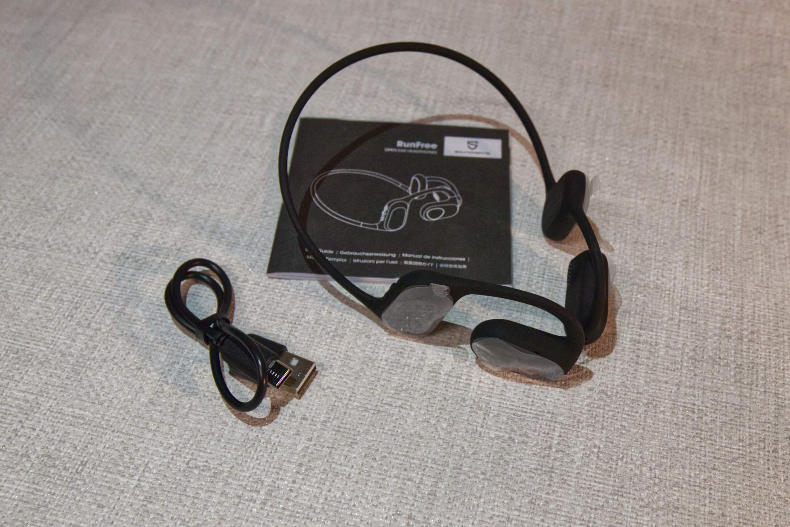 Photo shows the SoundPeats headphones next to their charger cable and the "how-to-use" manual