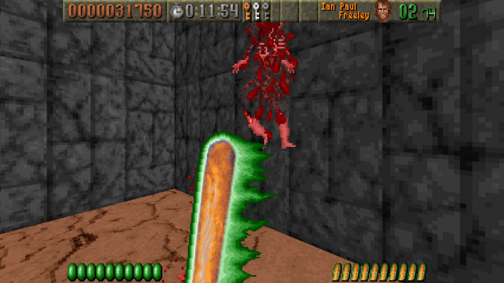 screenshot showing an fps view with Excalibat (a magical baseball bat with a green glow) as the weapon in use. Infront and in the air are the red bloody remains of an enemy soldier. The floor is light brown and cracked and the high walls behind are grey stone blocks.
