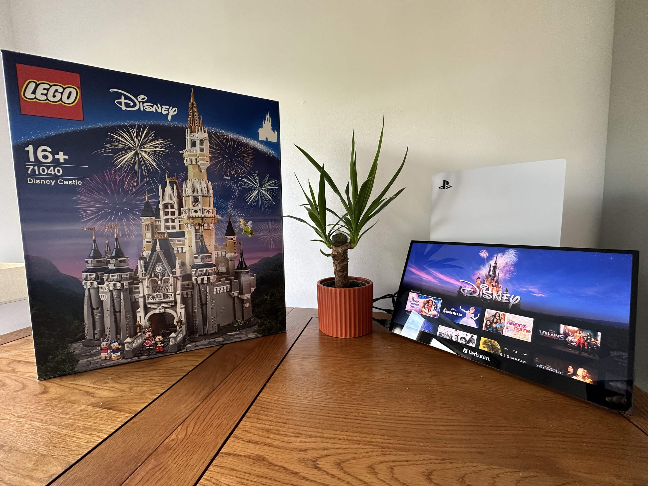 in this image is the verbatim pmt-17 monitor with Disney + on it next to a green plant and the LEGO Disney Castle waiting to be built