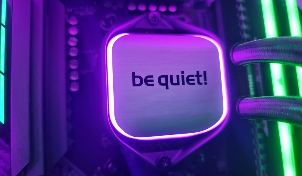 a lovely photo of the bequiet silver and black cooler block. A purple halo of light illuminates the outside of the brushed aluminium block as it glows against the motherboard.