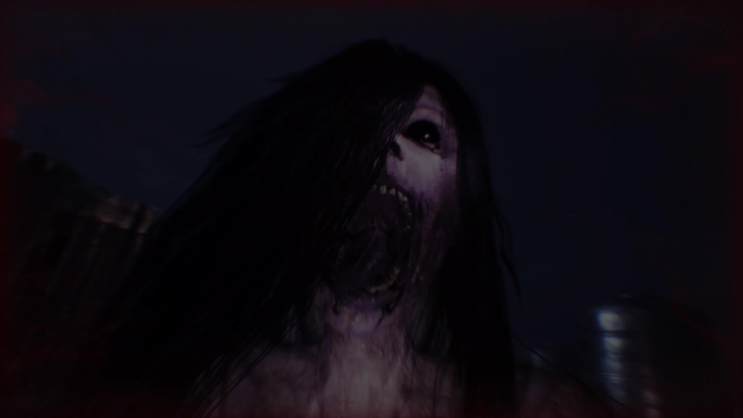A ghostly figure with black hair opens her mouth to attack you in a dark scene