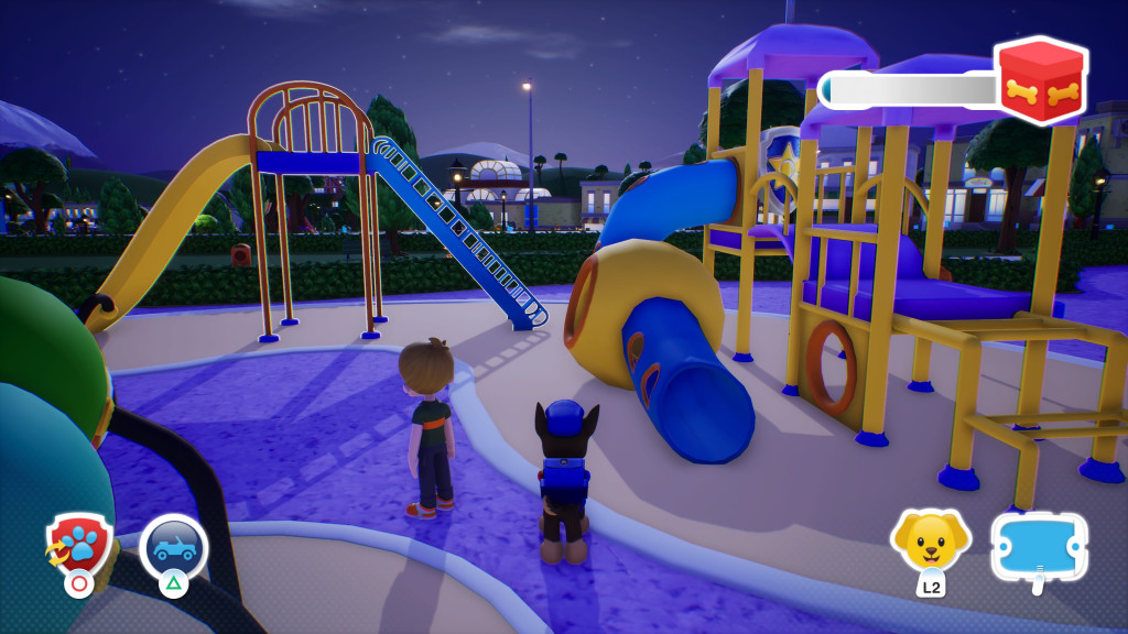 screenshot showing a play park featuring a yellow slide with a blue ladder and a yellow, blue and red climbing frame with chutes. Chase, wearing his blue police outfit stands on the path wondering what to play on next. A boy stands to his left and the sky is dark indicating it is the evening.
