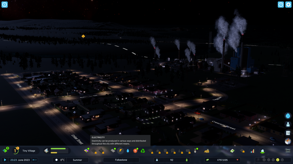 screenshot showing a night scene above the city. Plumes of grey smoke are seen against the dark skyline from the factories. Meanwhile streetlights illuminate the roadways. 