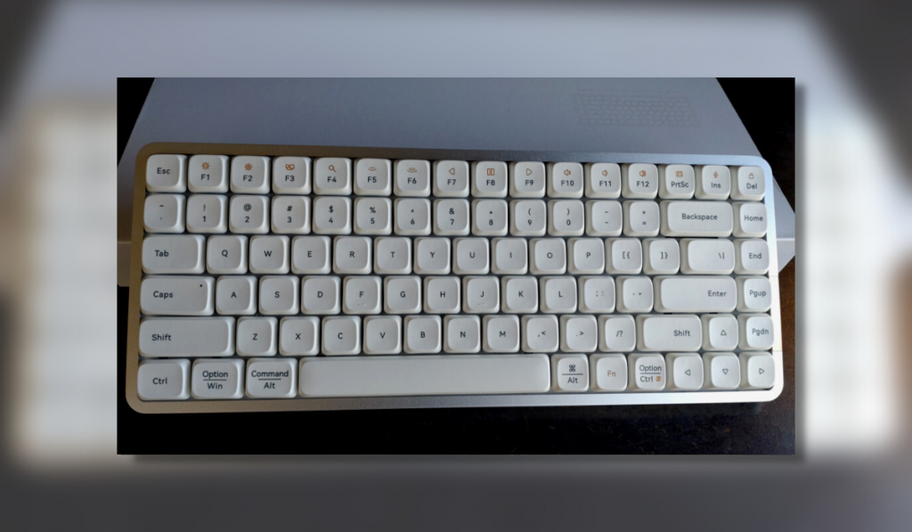 A white Lofree Flow keyboard, propped up against a white box
