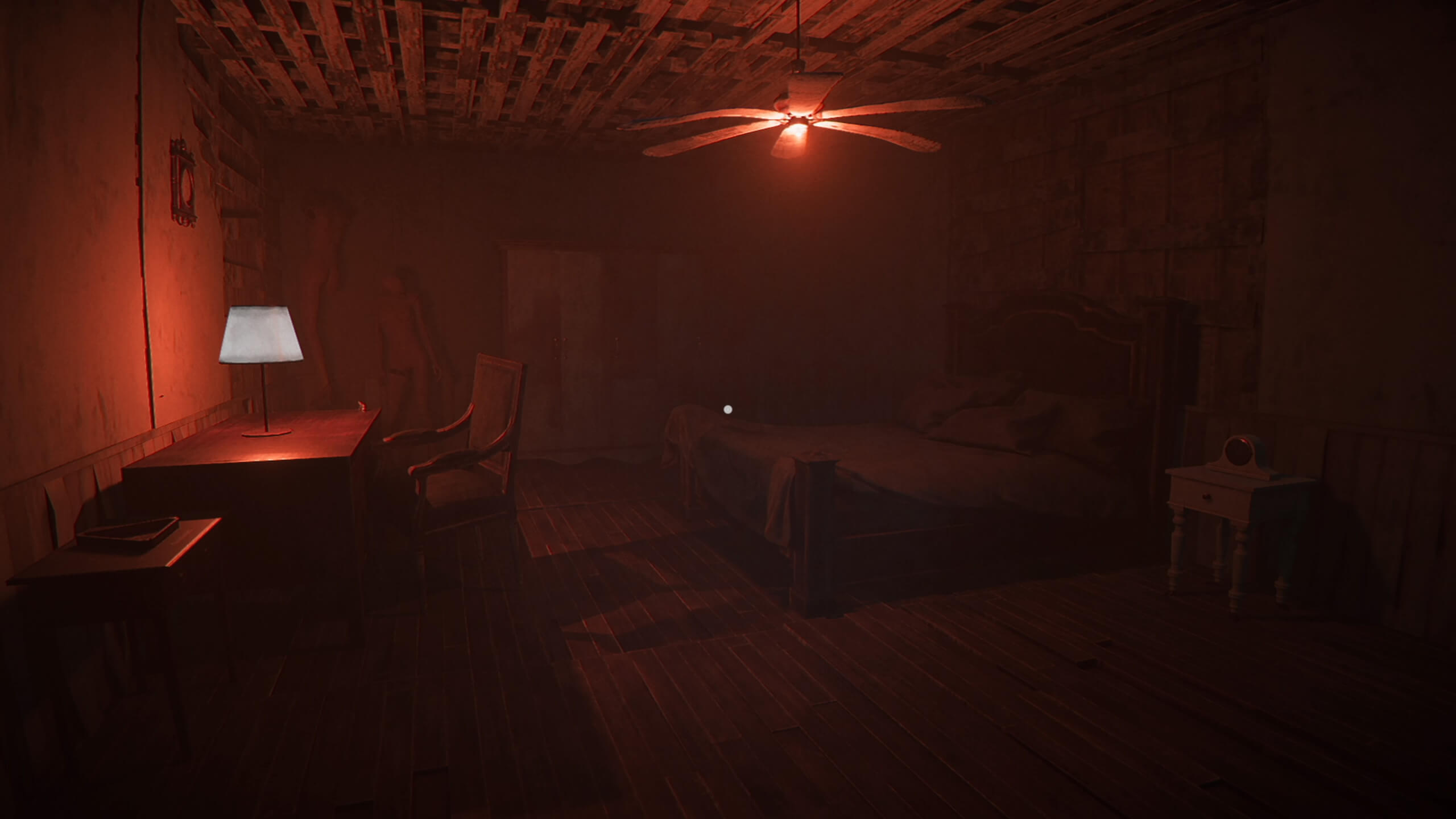 A dimly lit, dilapidated red tinted room. On the left is a table with a lamp on it. On the right is a double bed, and on the left against the wall are two mannequins.