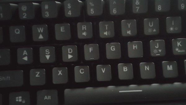 The keys of the keyboard are being pressed. Each time they are pressed, the keys and the backlight of the keyboard pulses in an array of rainbow colours.