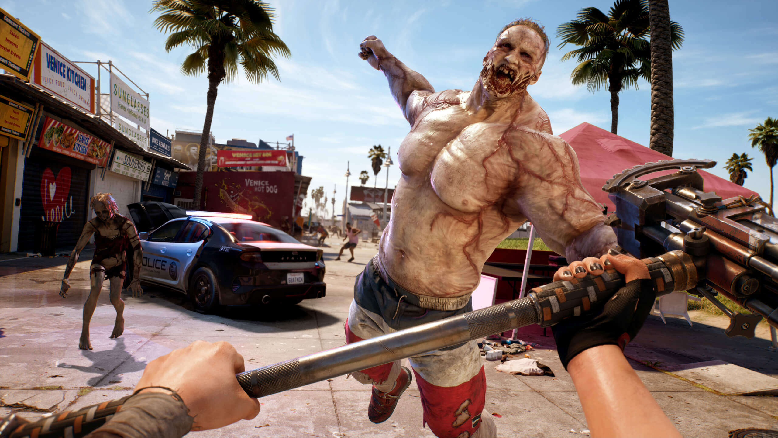 Screen shot 1 for the Dead Island 2. It shows a large undead lunging at the player who is holding a Sledge Hammer.