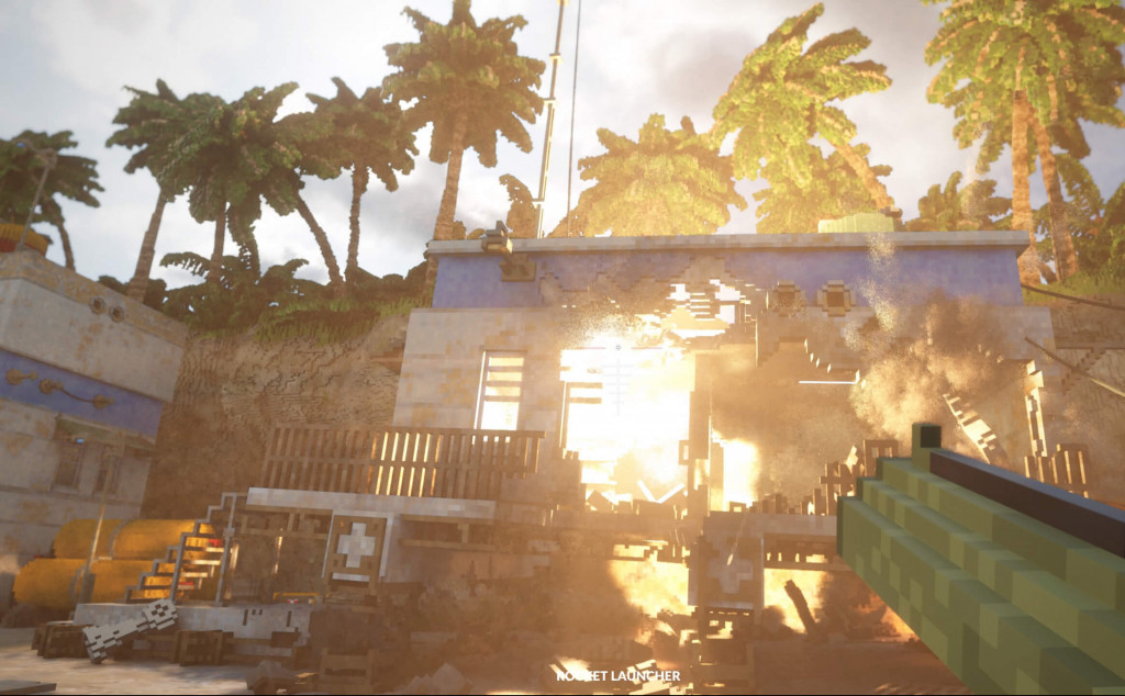 screenshot showing a tropical island with green palm trees along a cliff top. A rocket launcher is causing destruction in the blue and white concrete building that is in front. There are numerous holes and a fire rages.