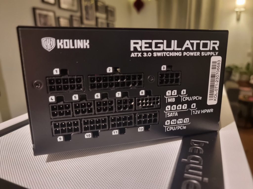 photo of the rear of the black rectangular Kolink regulator psu. There are 12 sockets shown to plug devices into