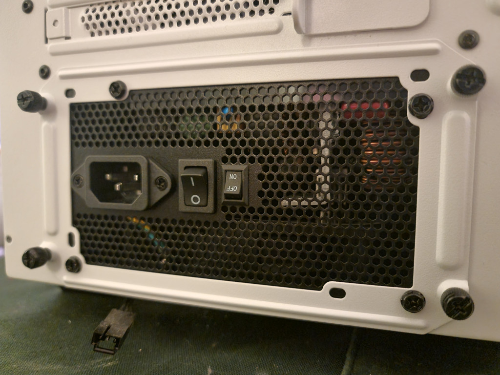 photo showing the kolink regulator psu installed into the white bequiet case. the psu looks upside down due to the writing of the semi-fanless mode being upside down.