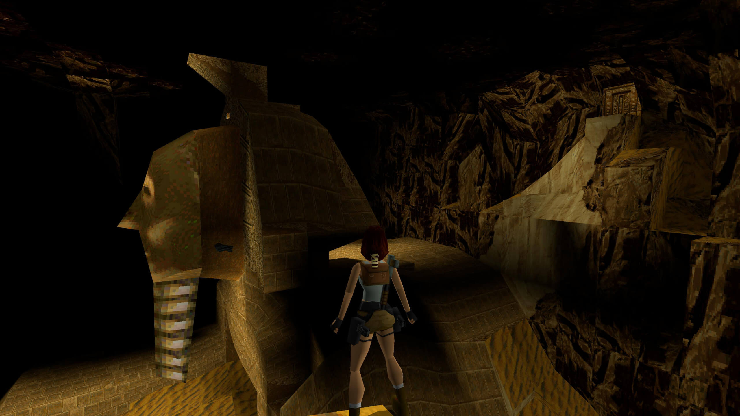 Lara stands on a ledge in the middle of an Egyptian ruin. Floating in the air in front of her is a pair of Uzis, one of the final secrets in this chapter