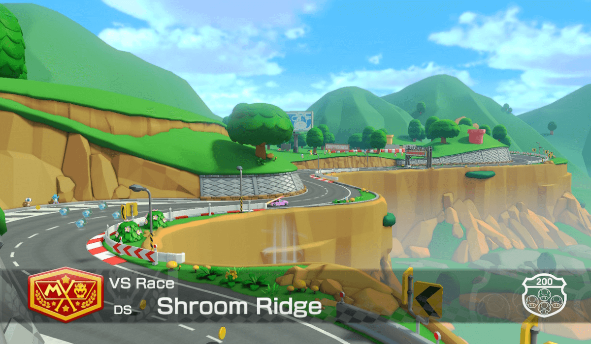 An establishing shot of Shroom Ridge, one of the returning tracks from MarioKart DS. It's been updated graphically to match the other tracks in MK8Deluxe, and shows a winding road along a canyon.