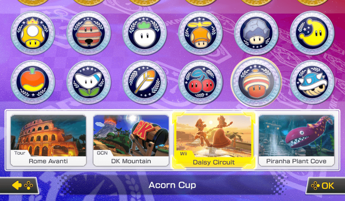 The track selection screen for the new tracks added by the Booster Course Pass. Each track is part of a new cup, each with their own symbol, like a moon, an acorn, or the iconic spiky Blue Shell.