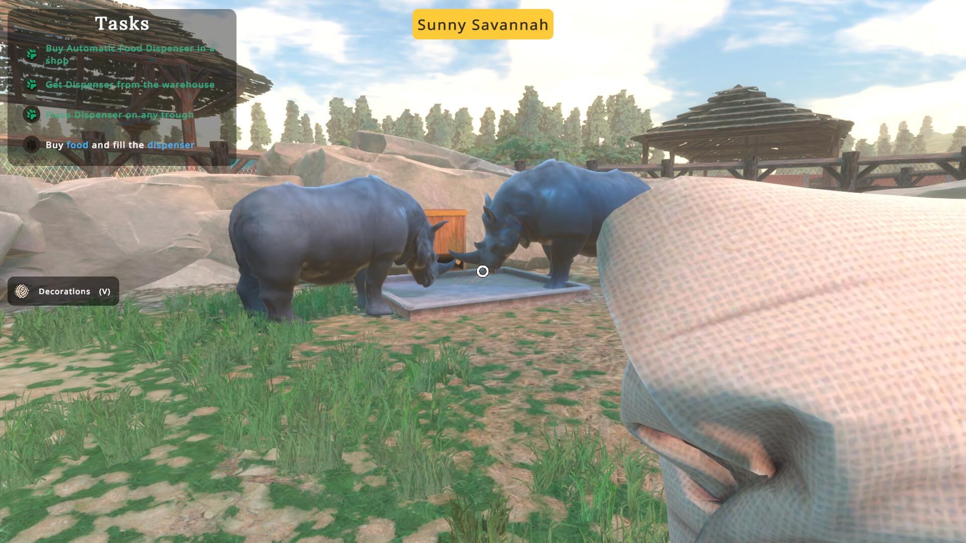 Two rhinos eating at the food dispensary. The above text "Sunny Savannah" is the name of the location itself.