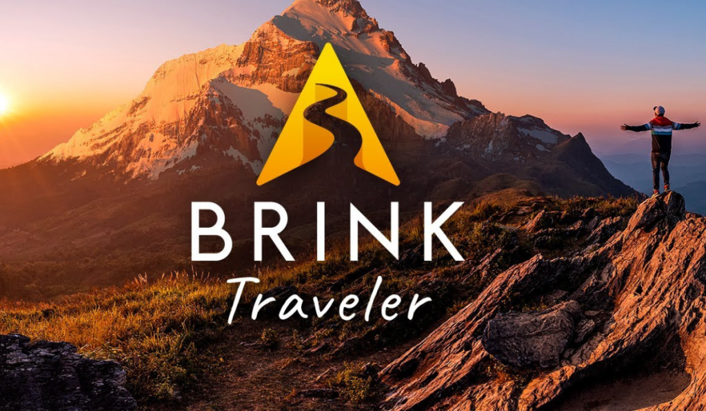 featured image for brink traveler showing a mountain scape with a person stood with arms wide.