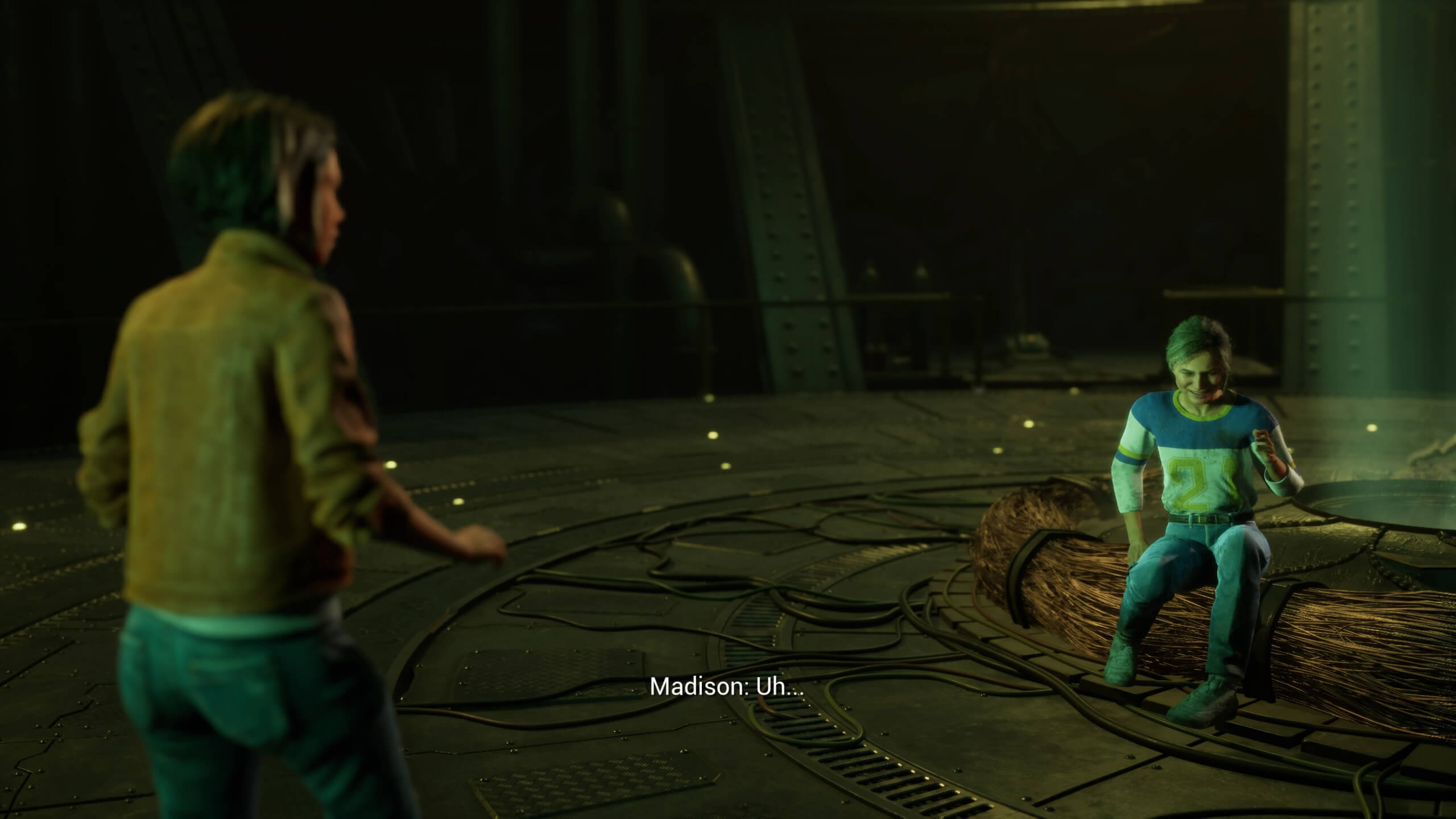 A shot of two characters about to have a conversation. One of them is sat down while the other has their back to the camera.