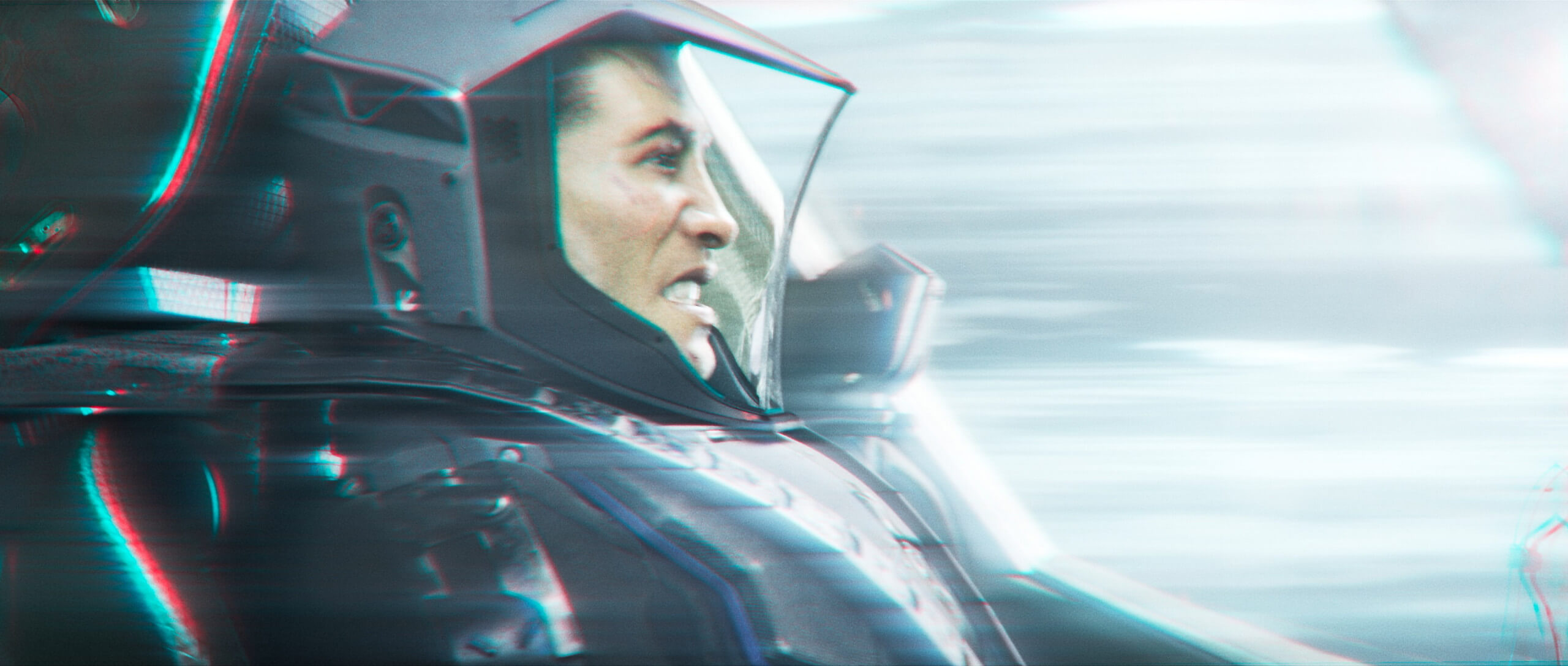 A masculine, human character wearing a space suit sits in a chair in a spaceship cockpit. They are staring forward with gritted teeth, and space seems to be warping around them, giving a sense of travelling at incredible speeds.