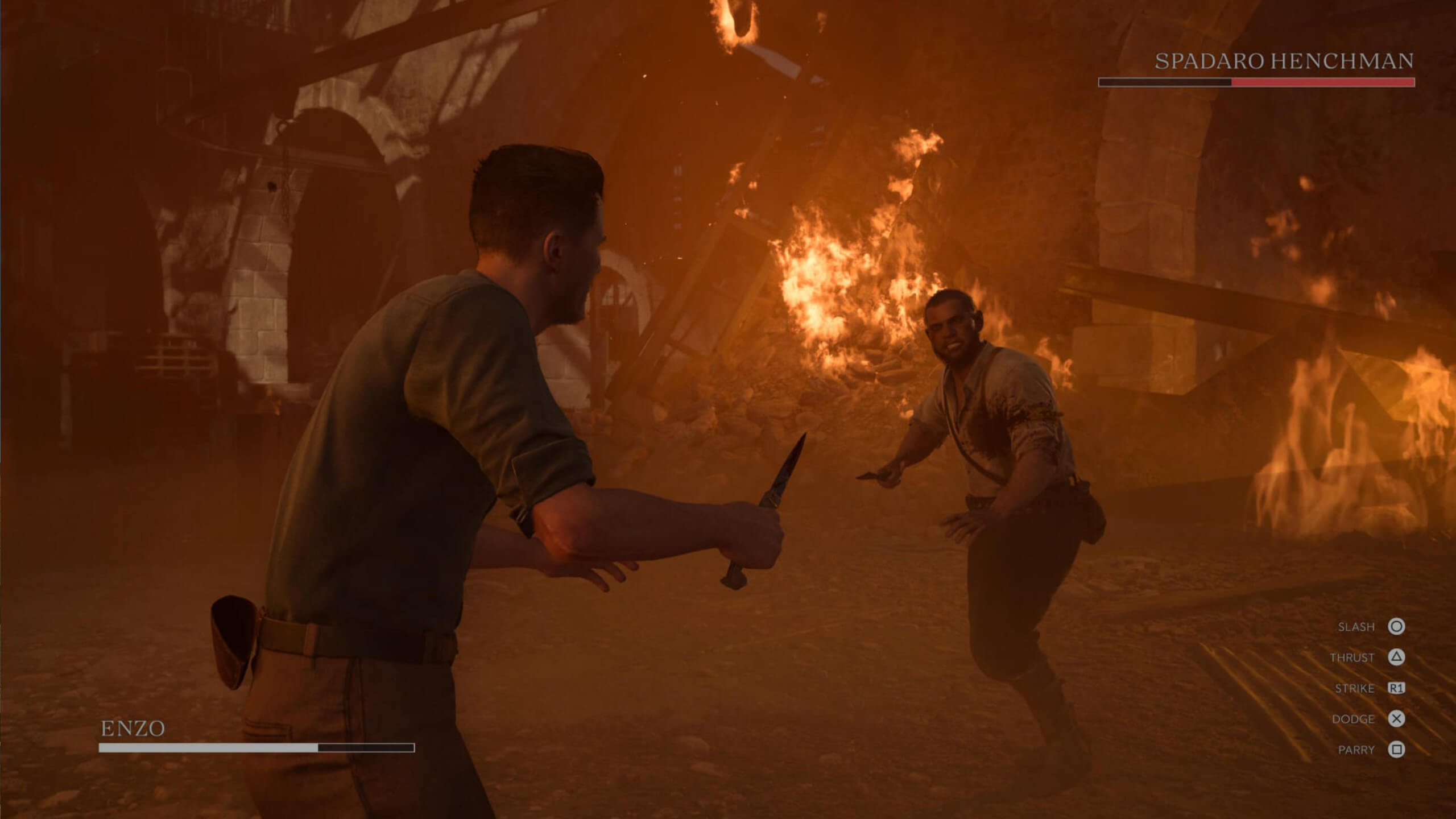 Screenshot from Mafia: The Old Country. A tense confrontation in a burning room: two men face off with knives, surrounded by flames and debris, evoking an intense and dramatic atmosphere.