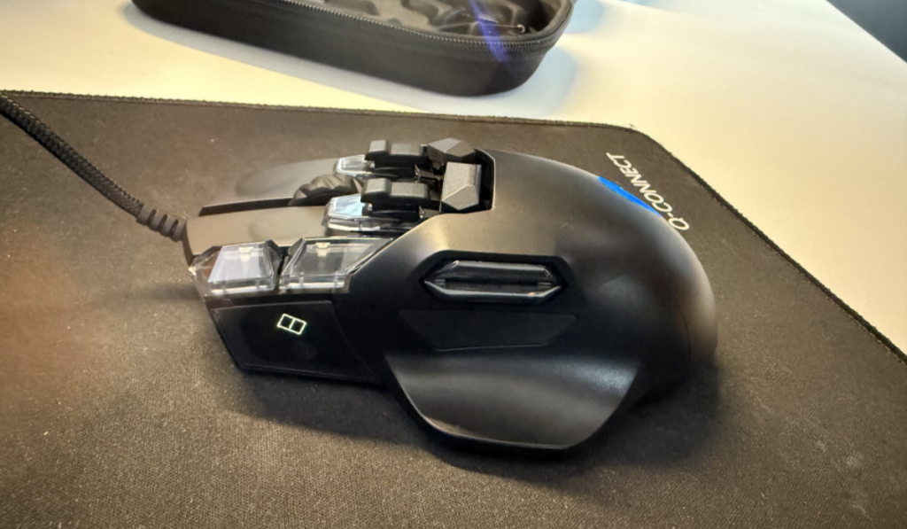 A black gaming mouse with multiple buttons on top, resting on a mouse pad, with a sleek design and a glowing SwiftPoint logo
