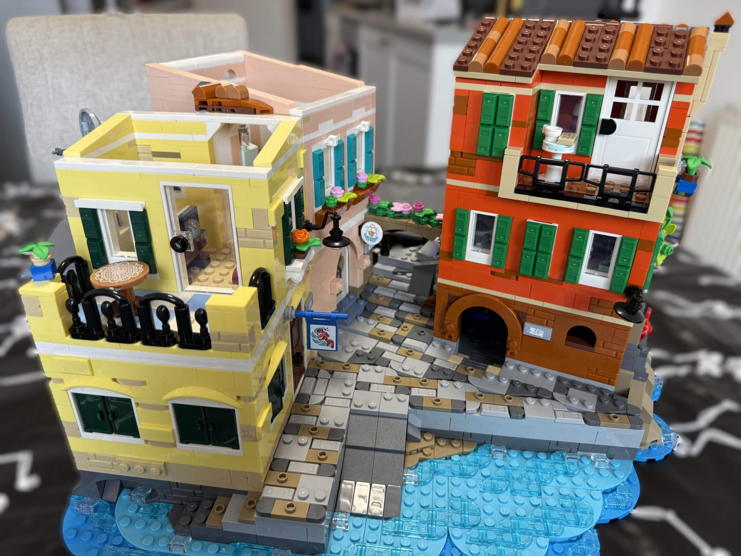 Close up of the fully built LEGO Italian Riviera featuring a boat on brick built lake and bright brick built buildings