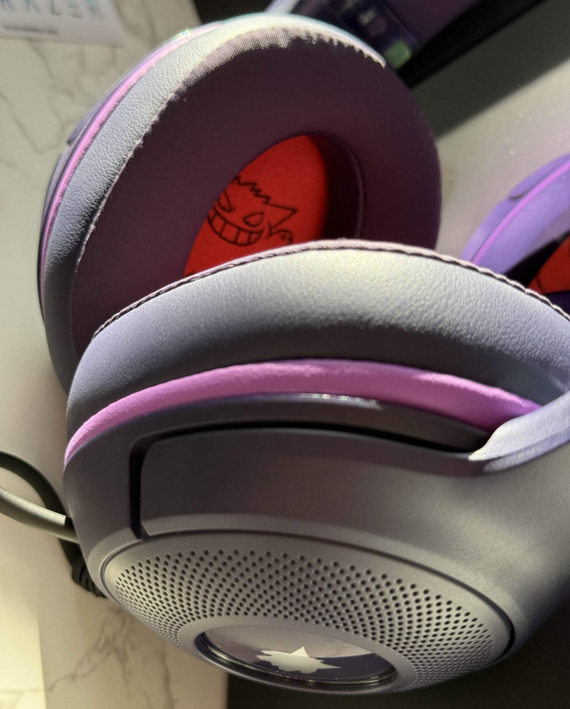 Close-up of the Razer kitty gangerh gaming headphones with red interior, featuring a smiling gengar pokemon character design visible on the ear cushion.