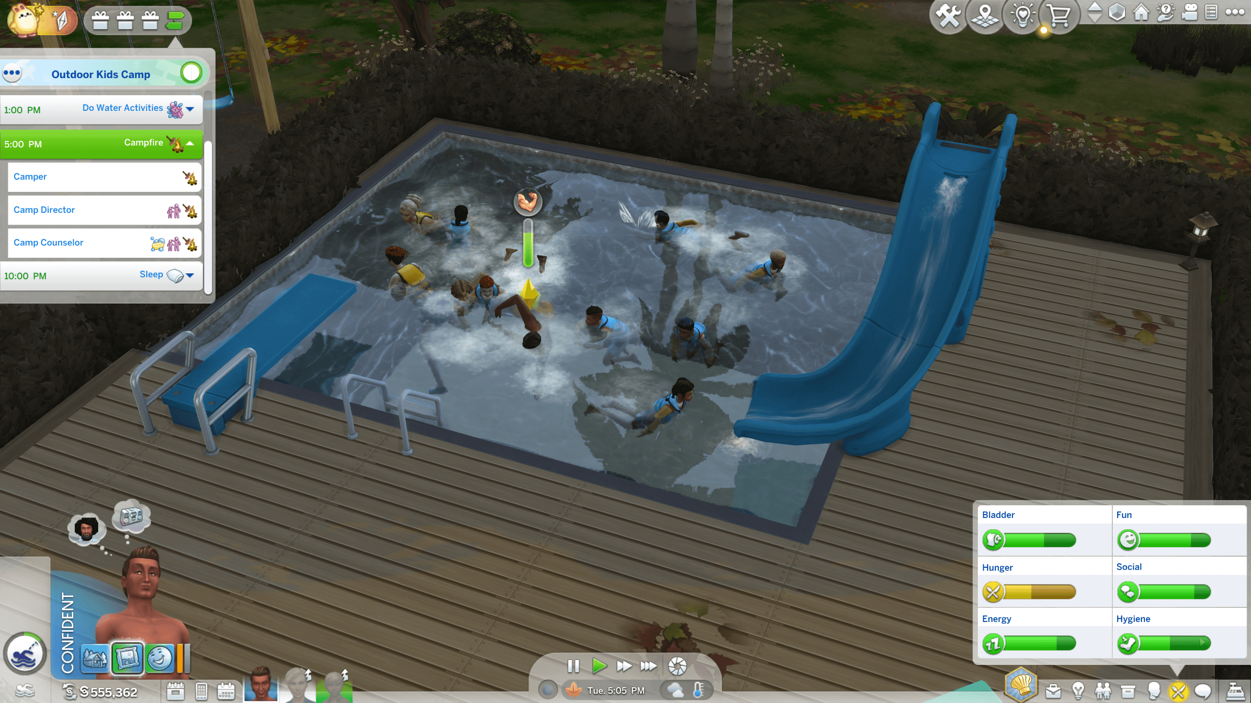 A lively outdoor pool scene at a kids camp, featuring children swimming and playing near a blue waterslide on a wooden deck.