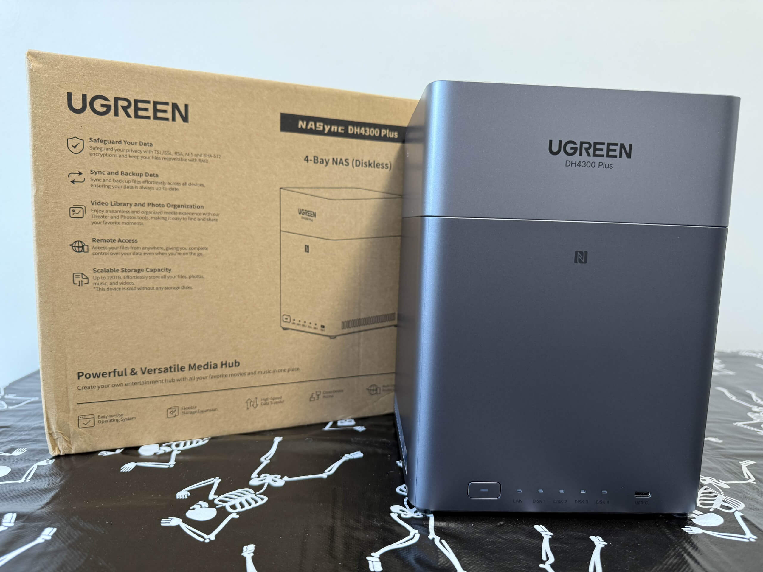 image of the ugreen nasync dh4300 plus from the front view, stoof next to its packaging box.