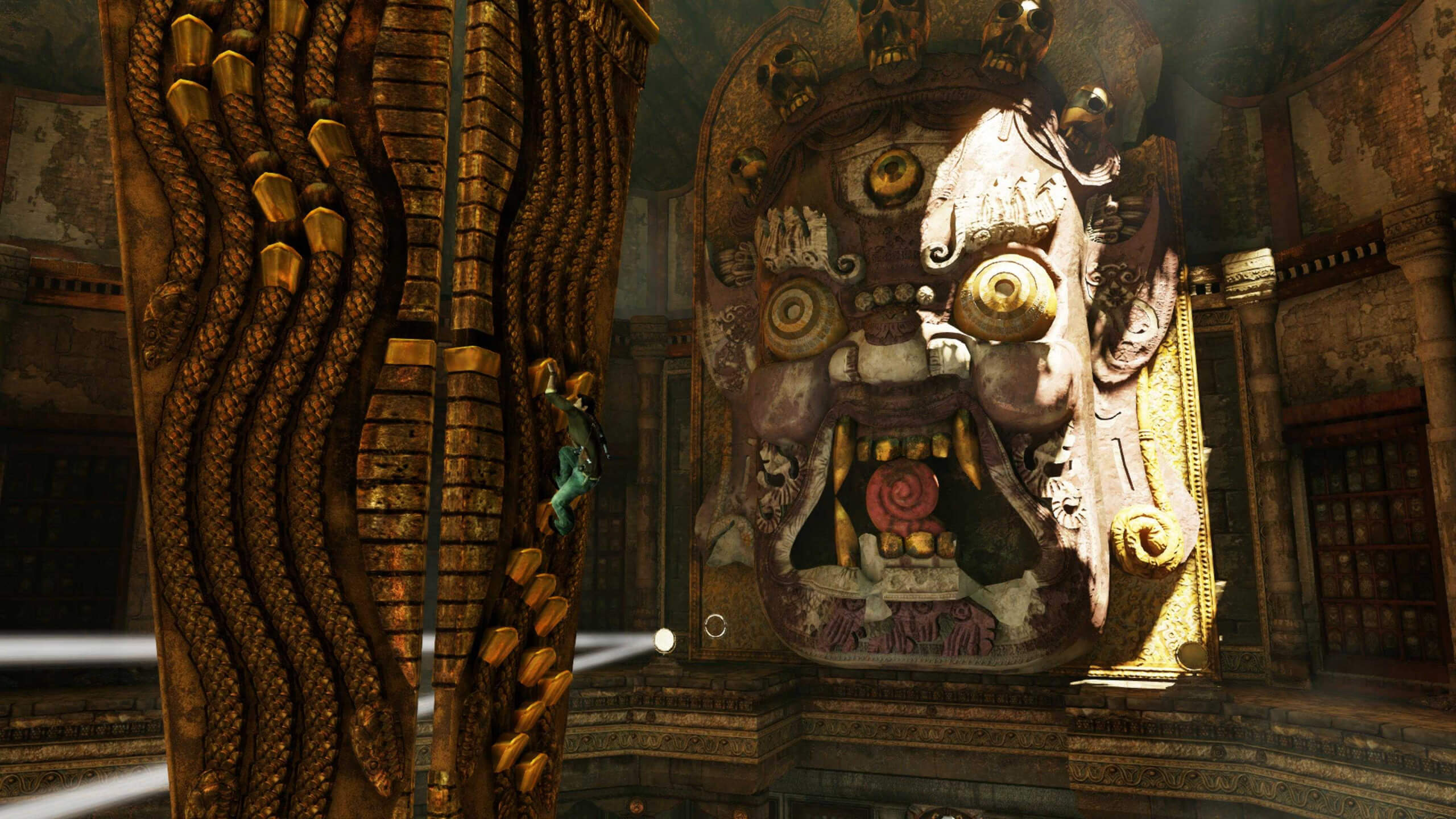Screenshot from Uncharted 2: Among Thieves. Nathan Drake climbing a ornate, golden pillar while a building-sized, ornate, sculptured mask looks on in the background.