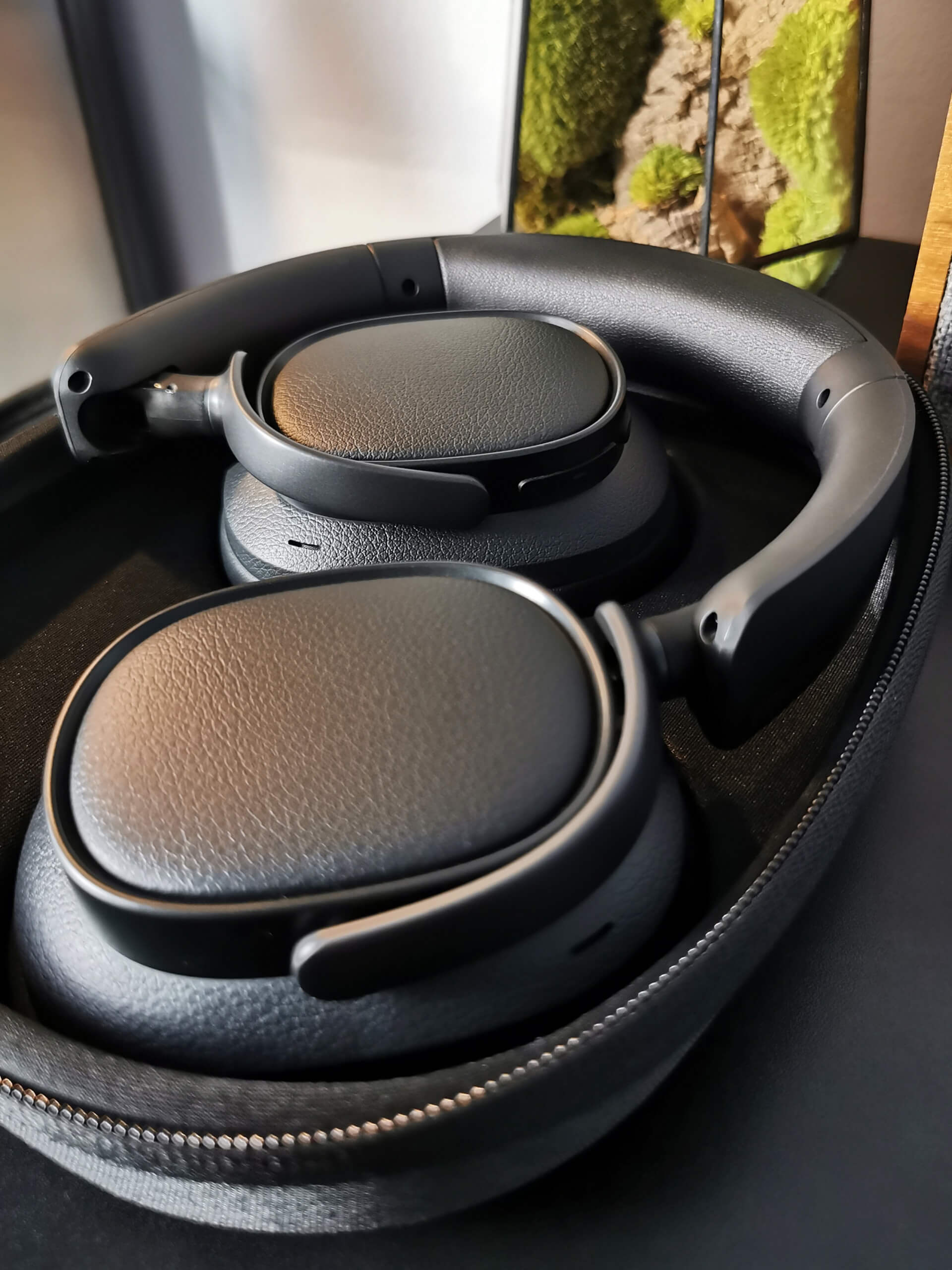 Edifier ES850NB pictured neatly folded away in their travel case shown open in black sat on a black desk