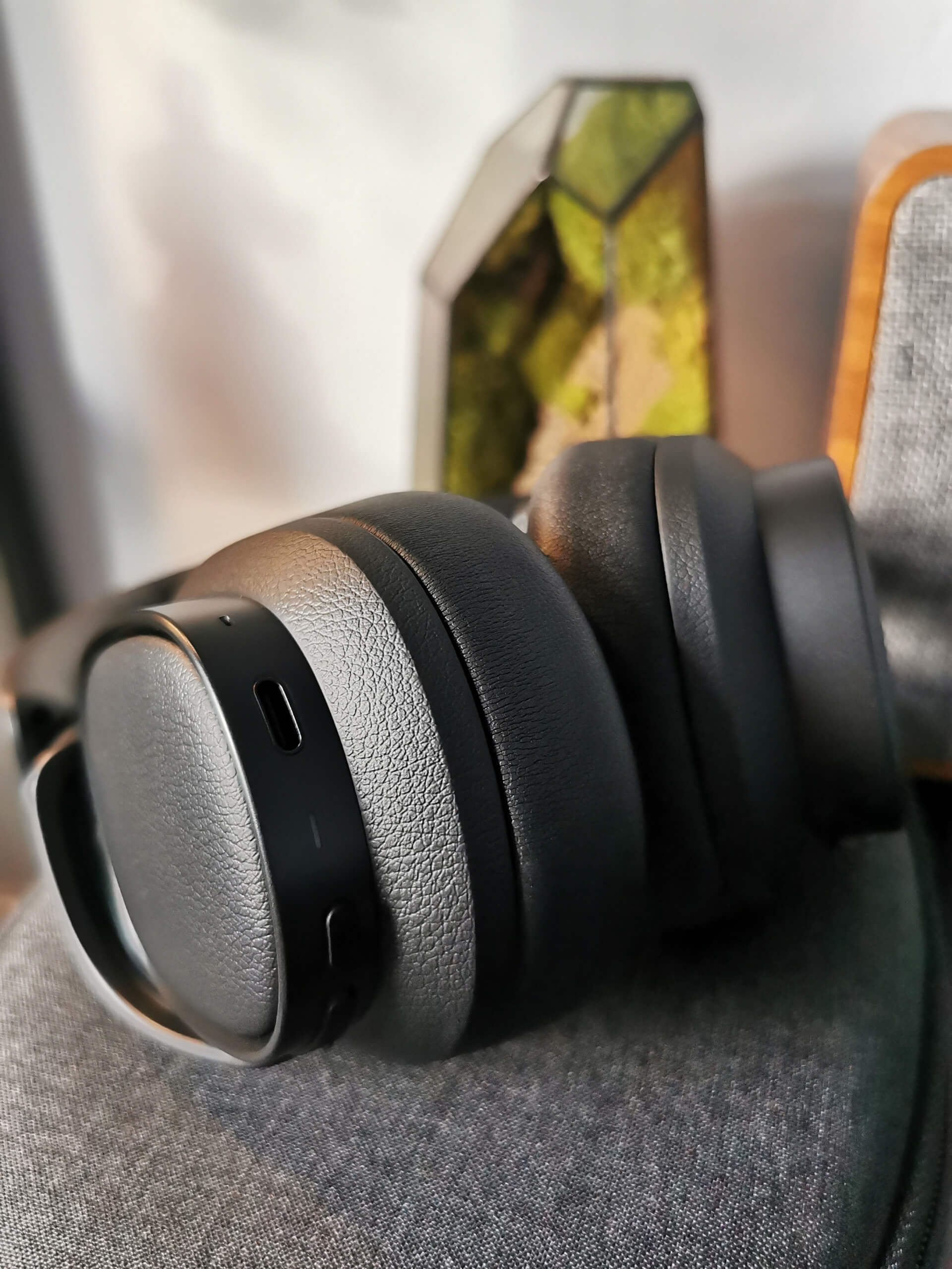 Edifier ES850NB pictured on their side showing the ports on the bottom of the right earcup and the soft black faux leather earpads.