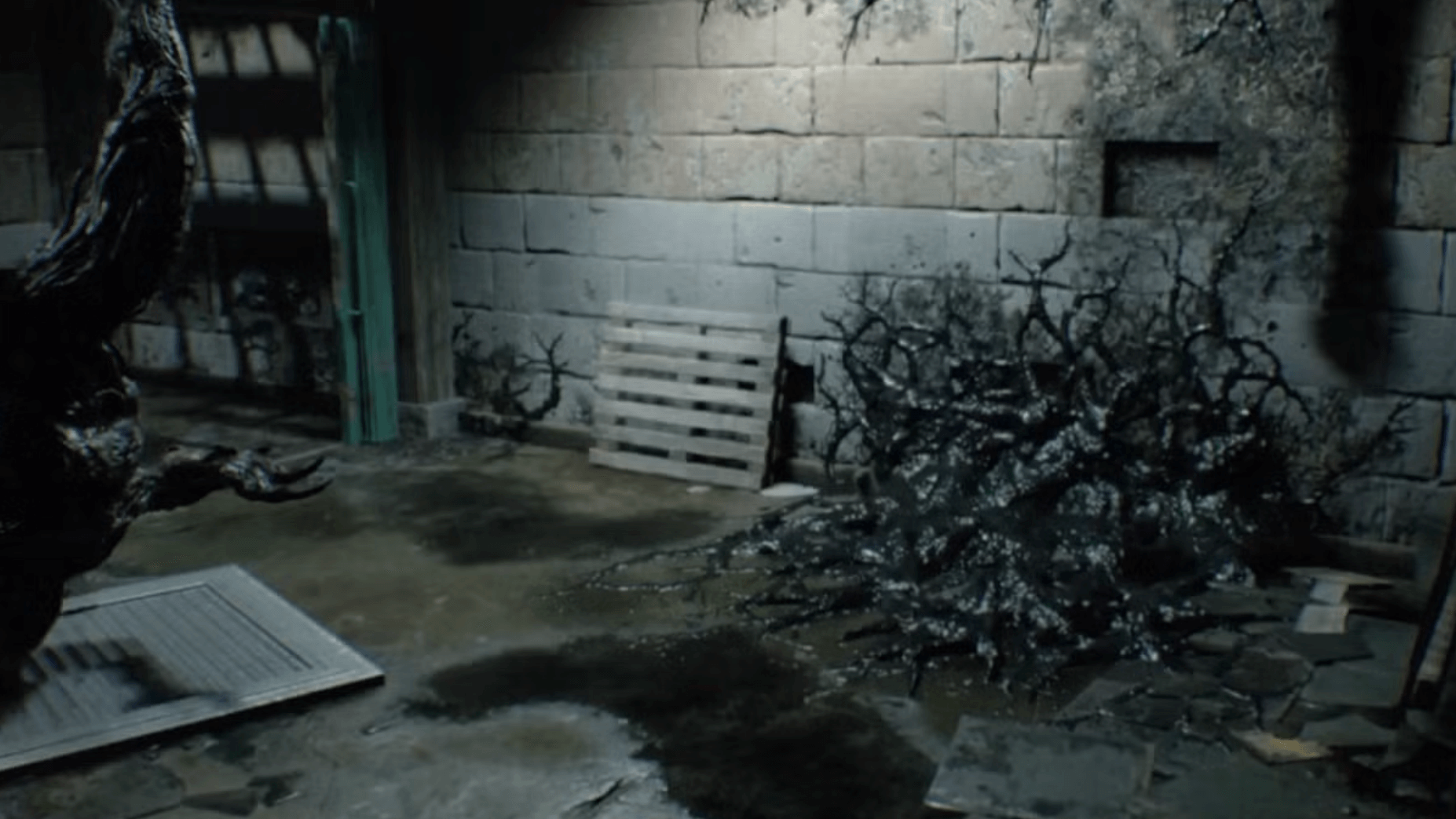 Dimly lit basement room with old stone walls, a wooden pallet, wet floor, and dark, twisted roots crawling over the ground, creating an eerie atmosphere.