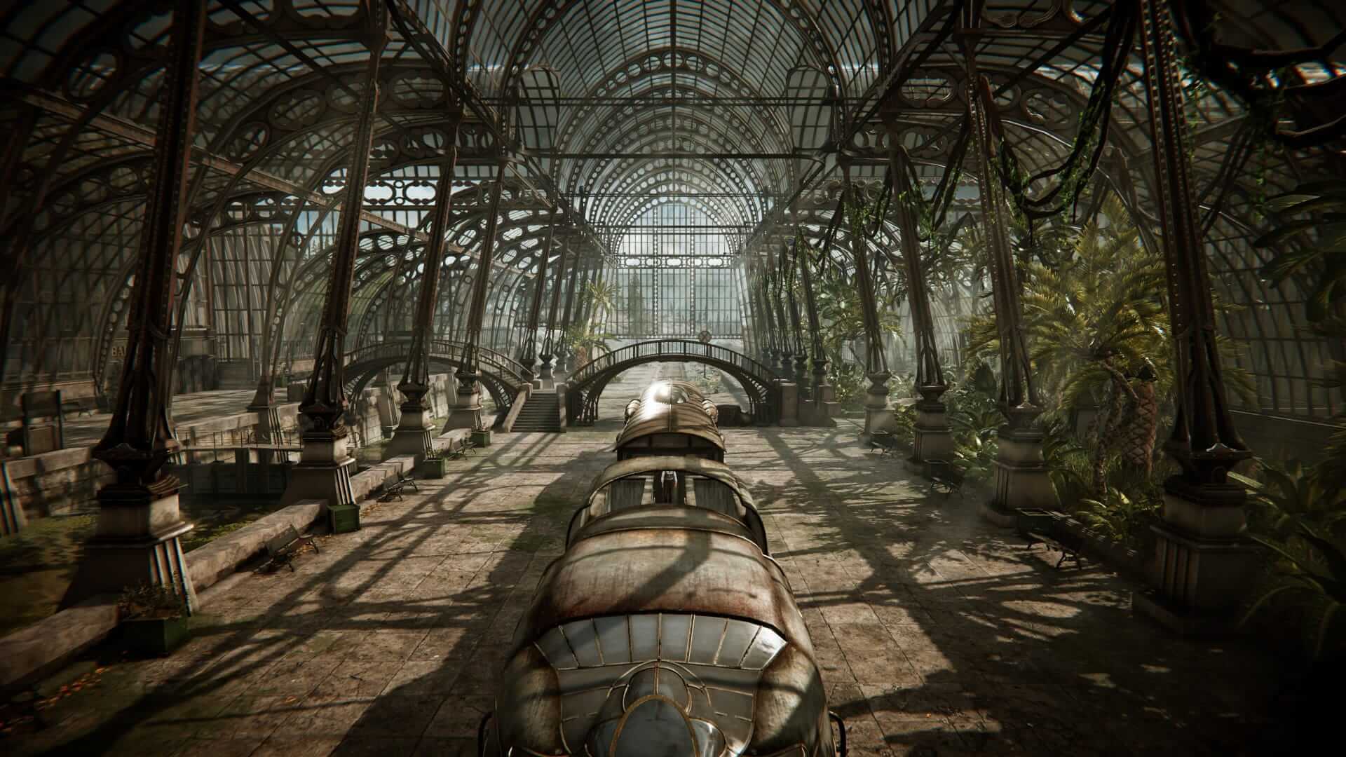 A vintage train sits inside a grand, sunlit glass conservatory filled with lush greenery. The scene evokes a sense of nostalgia and tranquillity.