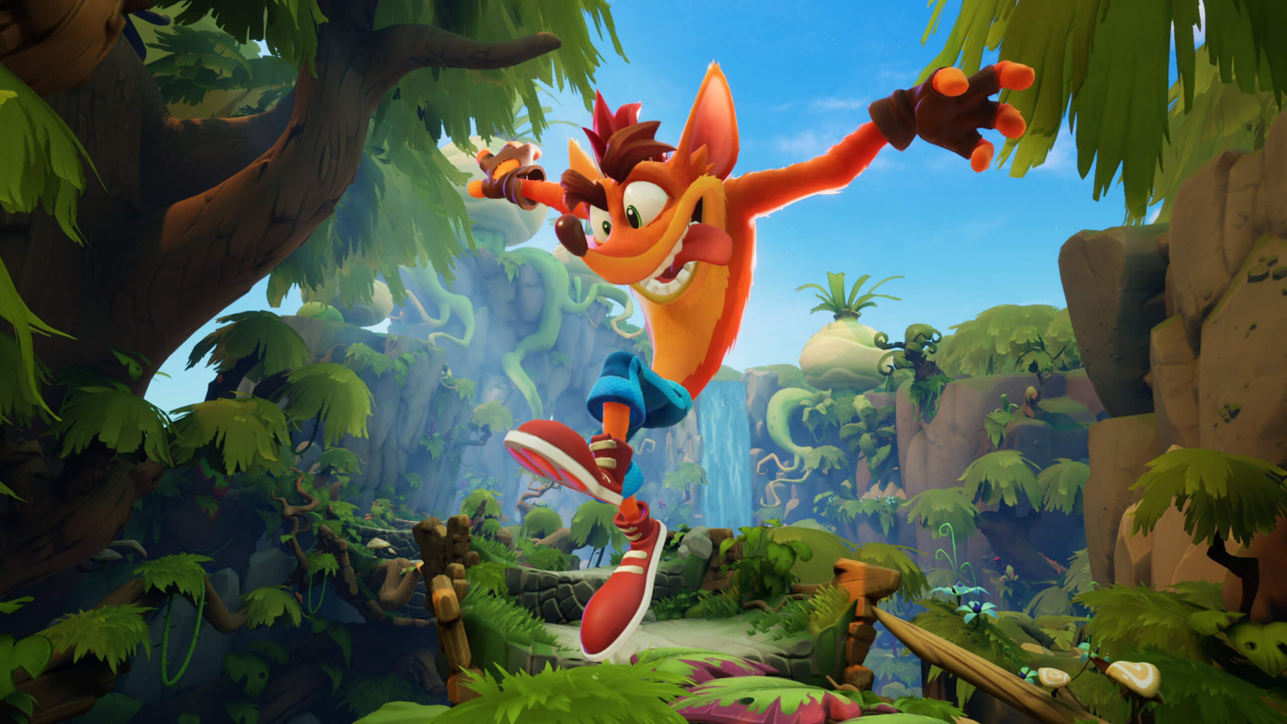 Crash Bandicoot, an animated character with bright orange fur and jeans, jumping joyfully in a lush jungle setting. The background shows trees, vines, and a blue sky.