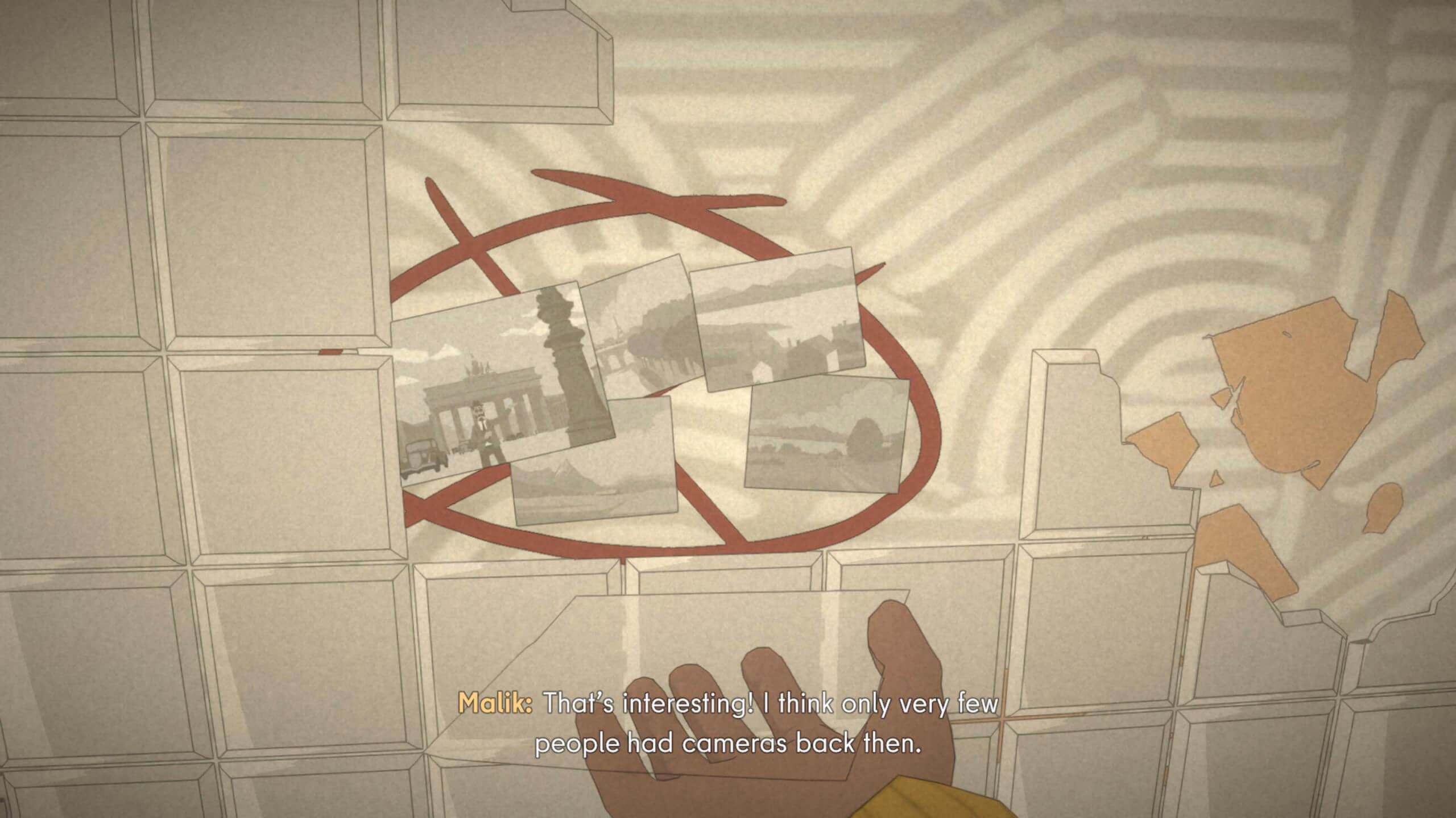 A hand holds the outline of a photo that hasn't been loaded in. In the background is another collection of photos stuck to a wall, hidden behind tiles.