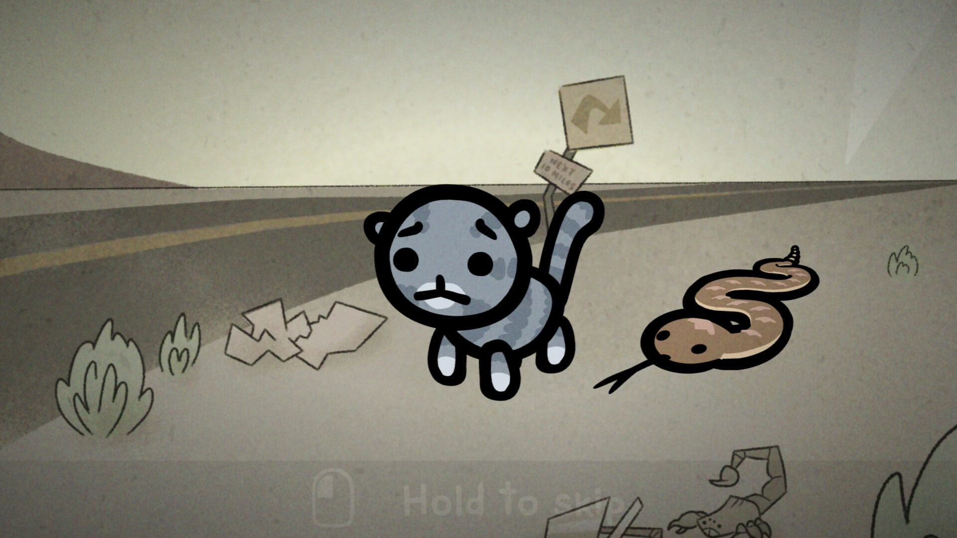 A blue kitten out in the desert with a brown snake beside it. The kittens face looks confused/upset. 