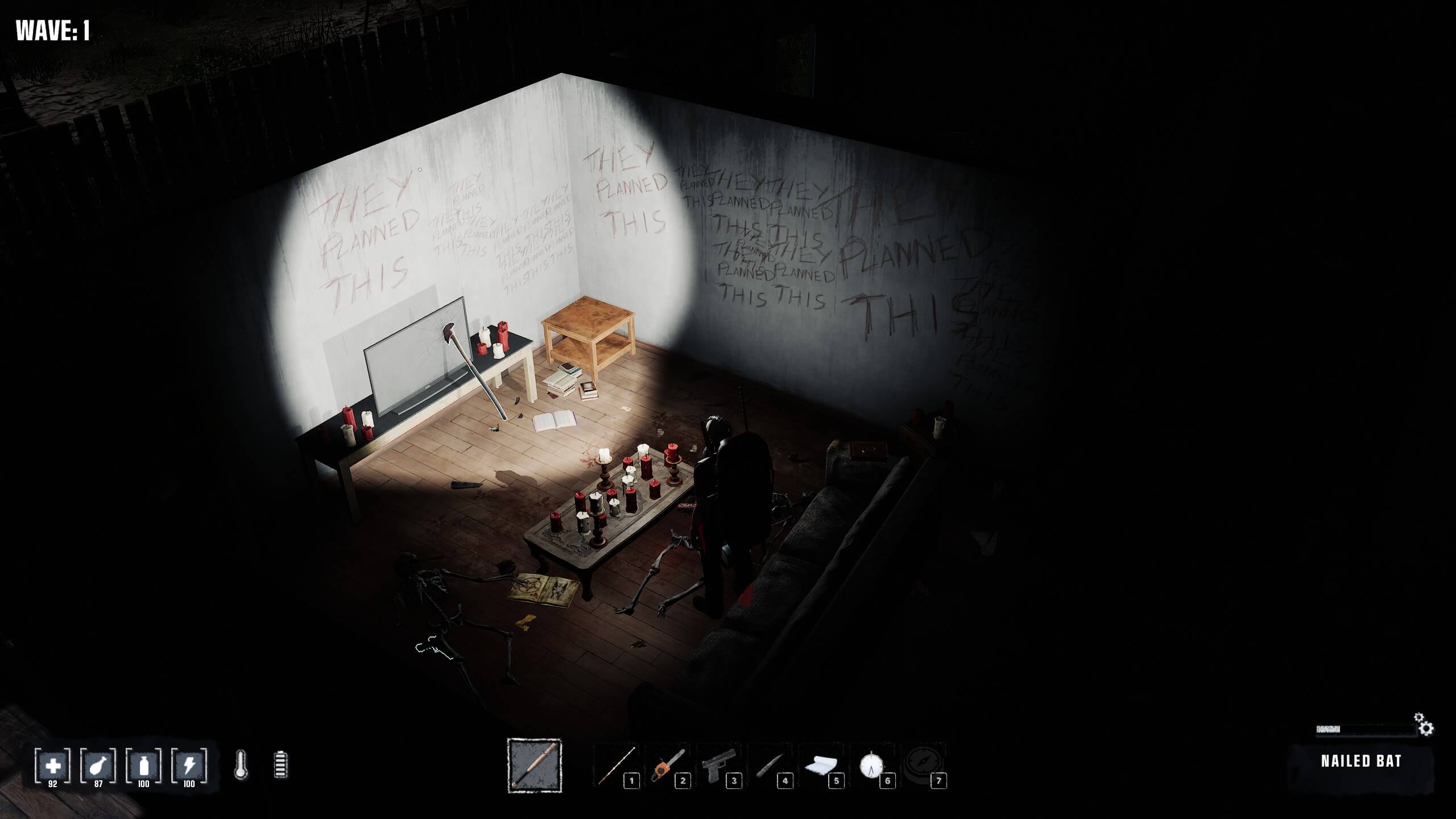Dimly lit room with walls covered in graffiti saying "They planned this." A figure stands near a table with candles and a skeleton on the floor.