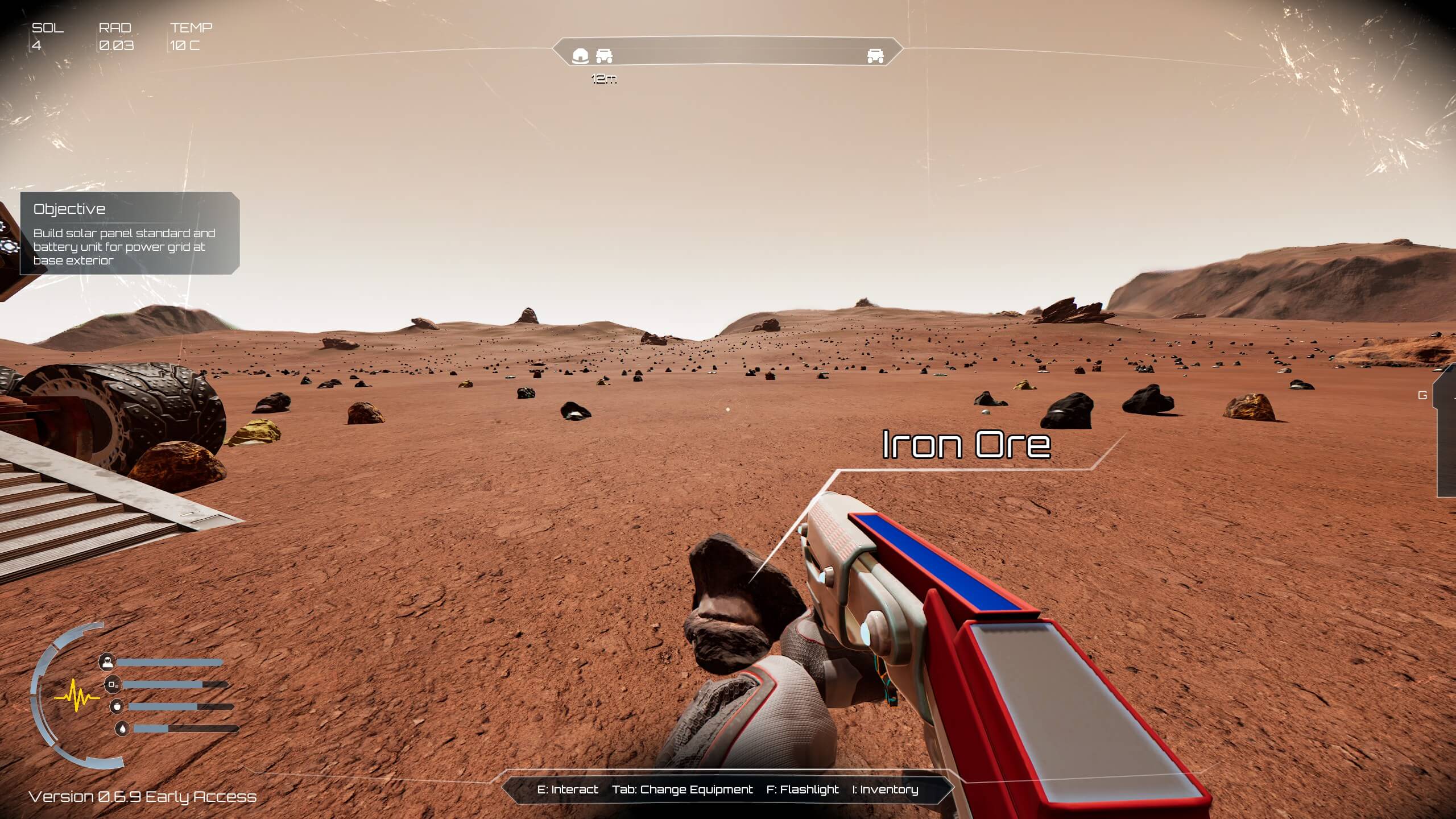 A player on an alien terrain holds a tool to collect iron ore, with rocky landscape and mission objectives displayed. The rocks littering the ground in front of the player are plentiful and can be seen stretching into the far distance.