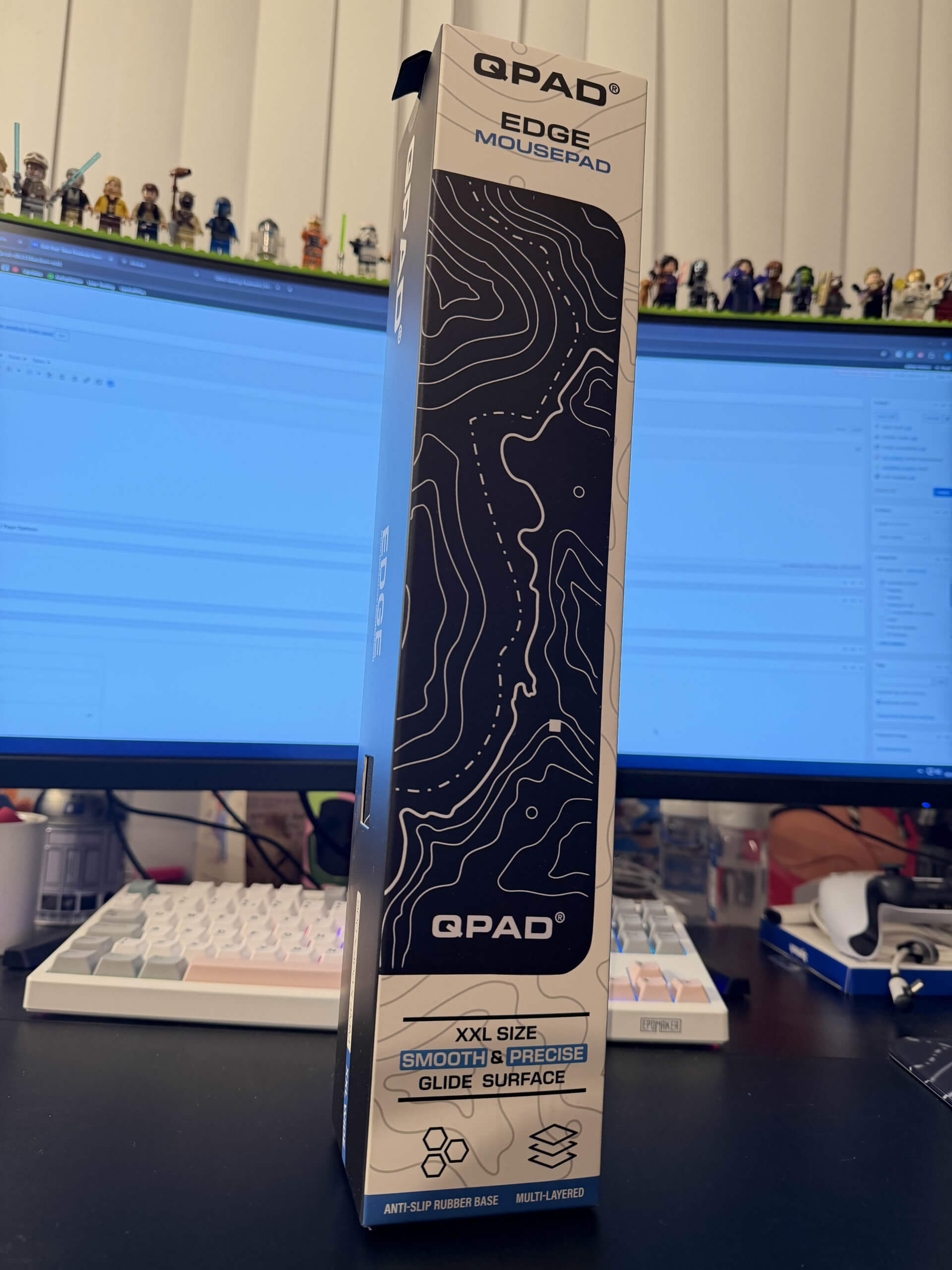 image of the edge mousepad box standing tall in front of a PC monitopr