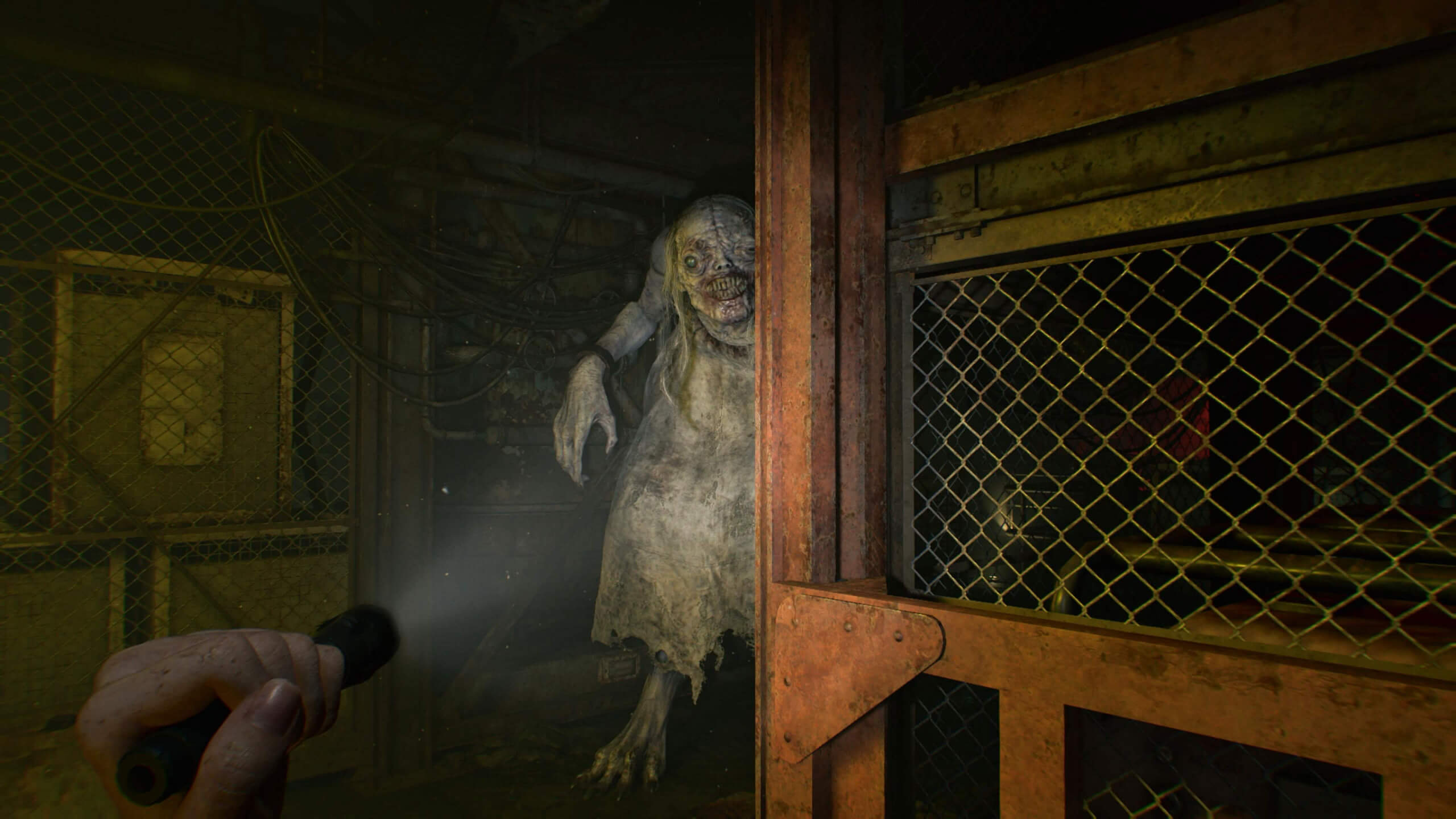 A dimly lit room with a figure resembling a ghost or monster lurking behind a wooden barrier, illuminated by the beam of a flashlight held in the foreground.