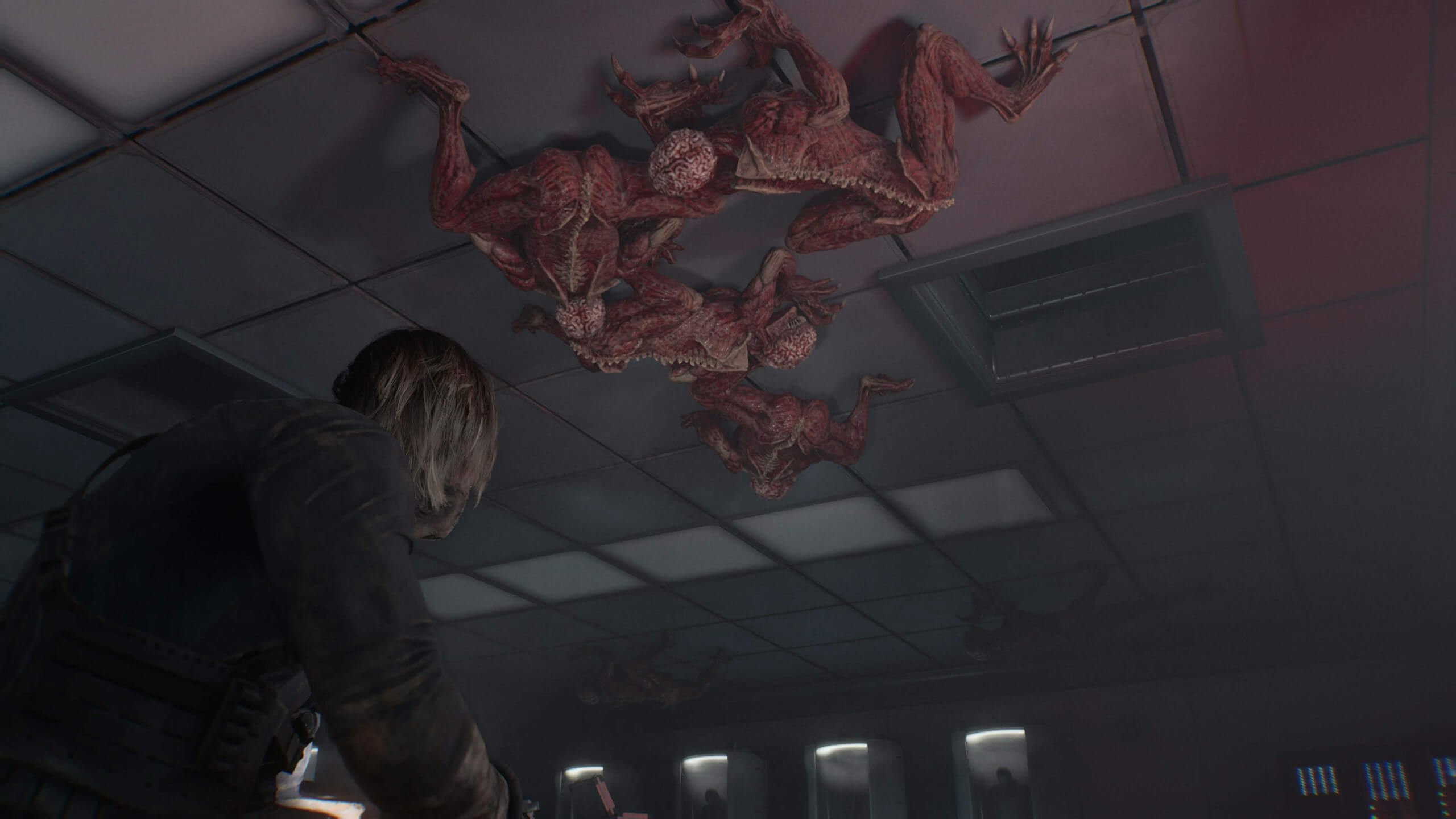 A character in a dark room looking up at menacing creatures on the ceiling.