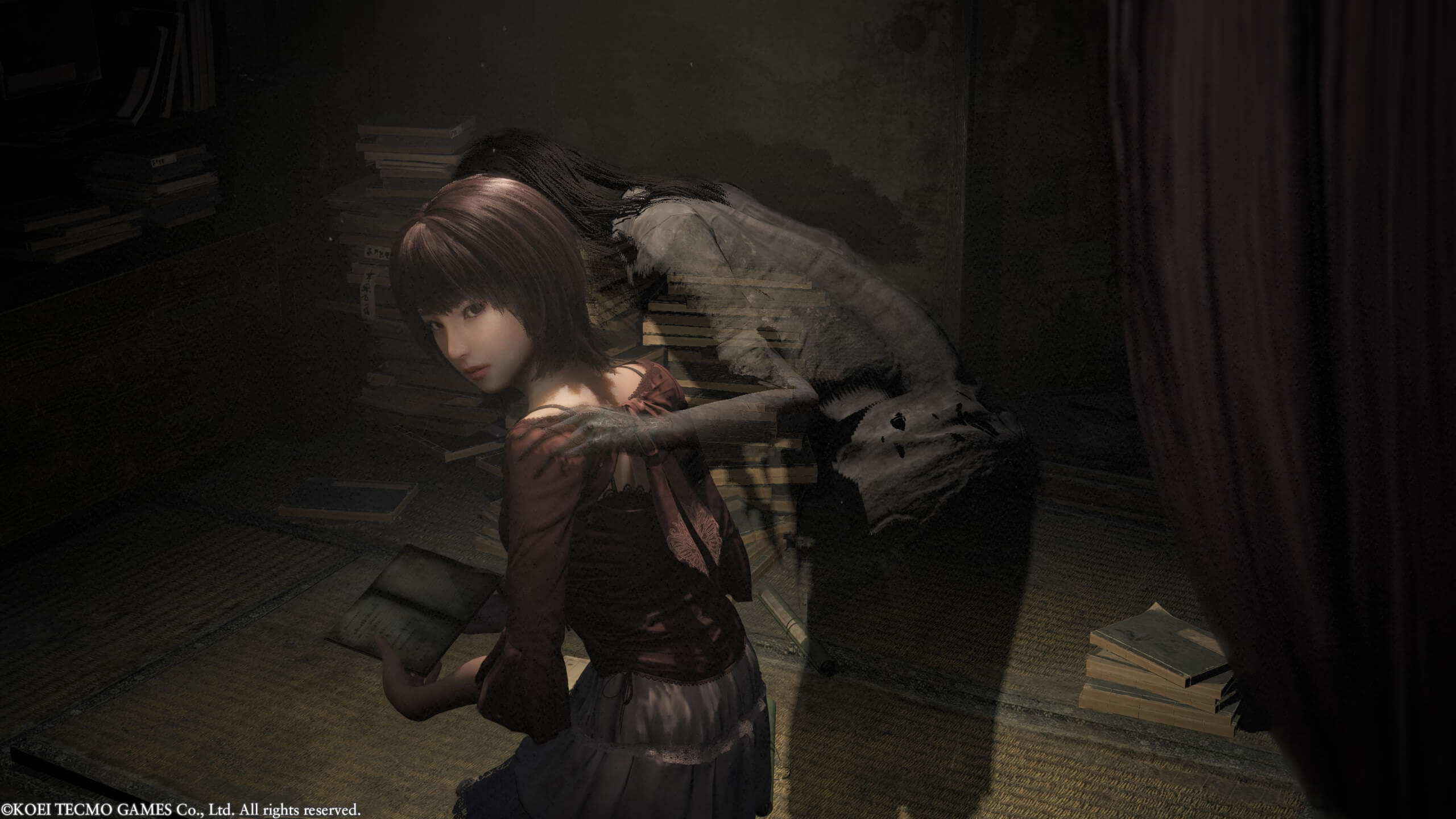 Mio is kneeling down whiling looking towards her sister, Mayu. A ghost is leaning over Mio's shoulder, but she has yet to notice. 