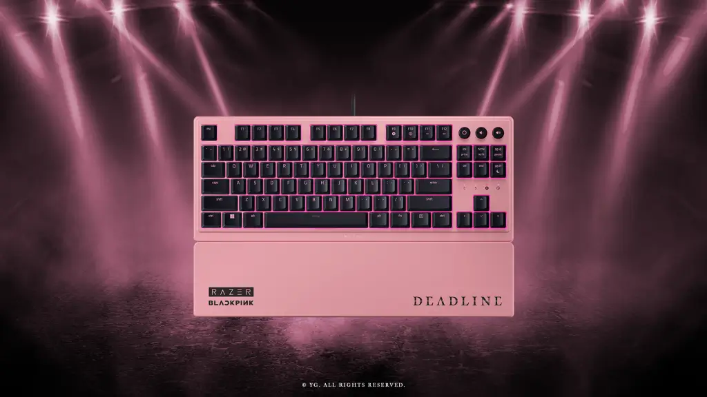 A stock image of the Razer Ornata V3 Tenkeyless – BLACKPINK Edition. Pink and black mechanical keyboard with wrist rest, Razer Blackpink branding, under pink stage lights.